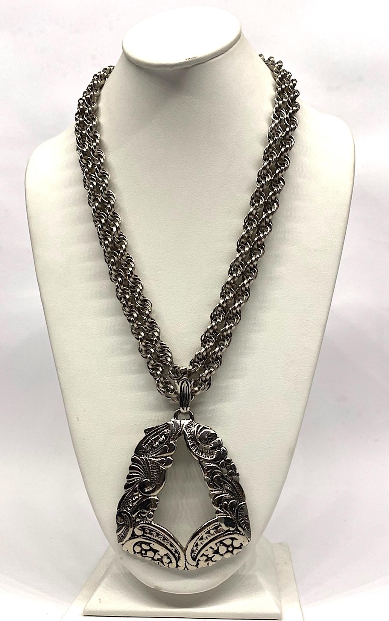 A vintage Lucien Pieccard 1970s statement pendant necklace. The two rope chains and pendant are rhodium plate in an antique silver color. The two rope link strands are .38 of an inch in diameter and meet at a satin silver color round push pin box