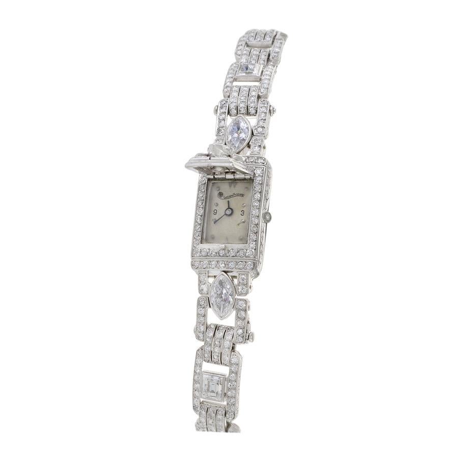 This Lucien Piccard watch speaks to the extraordinary design aesthetic of the 1950's. The bracelet watch is crafted out of platinum and 12.00CT-TDW of high quality diamonds. The face of the watch is covered by a diamond encrusted cover that adds to
