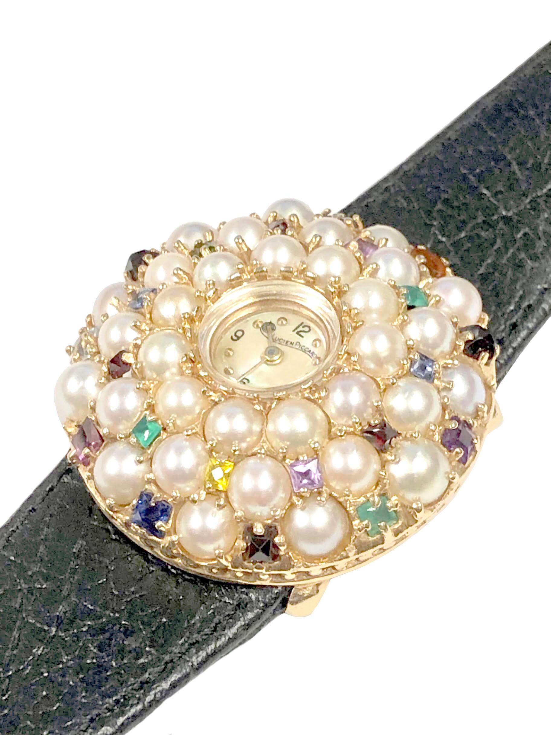 Circa 1960s Lucien Piccard Ladies Wrist Watch, the 14k Yellow Gold case measures 36 M.M. in diameter and 10 M.M. in thickness / height, set with Round Cultured Pearls measuring 4.5 M.M. and further set with Square Step cut and French Cut Emerald,