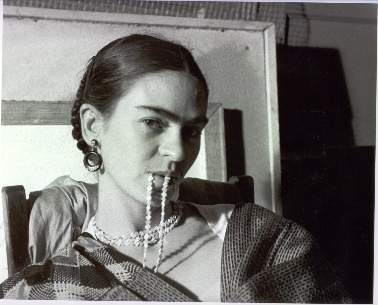 Frida Biting Her Necklace de Lucienne Bloch est un tirage à la gélatine argentique de 8 1/4 x 10 1/4 pouces. Cette photographie est montée sur un support de 16 x 20 pouces avec un passe-partout. Elle est signée au stylo au recto par l'artiste et