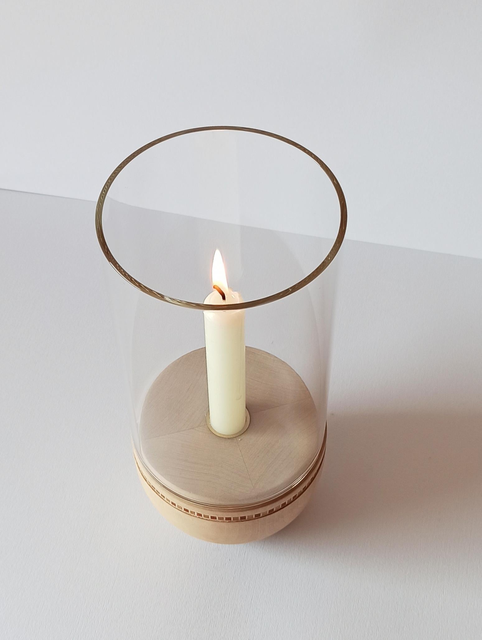 Inspired by old lanterns, Lucille is a collection of candle holders with a simple and minimal style. Made of turned wood, they are adorned with a small inlaid decoration and equipped with a firewall glass. The inlay is inspired by the geometric