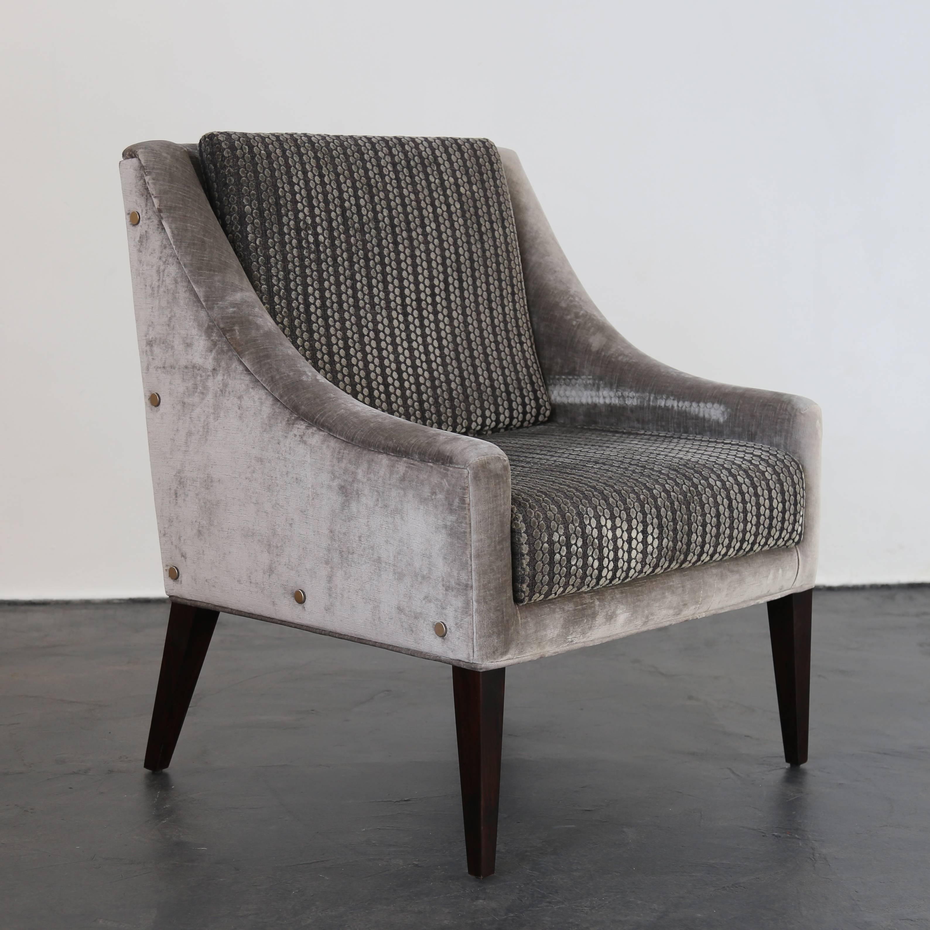 This elegant lounge chair with contrasting Kravet fabric and polished steel button details features gently sloping arms and dark Argentine Rosewood legs. Available as shown for immediate delivery or in your custom upholstery.