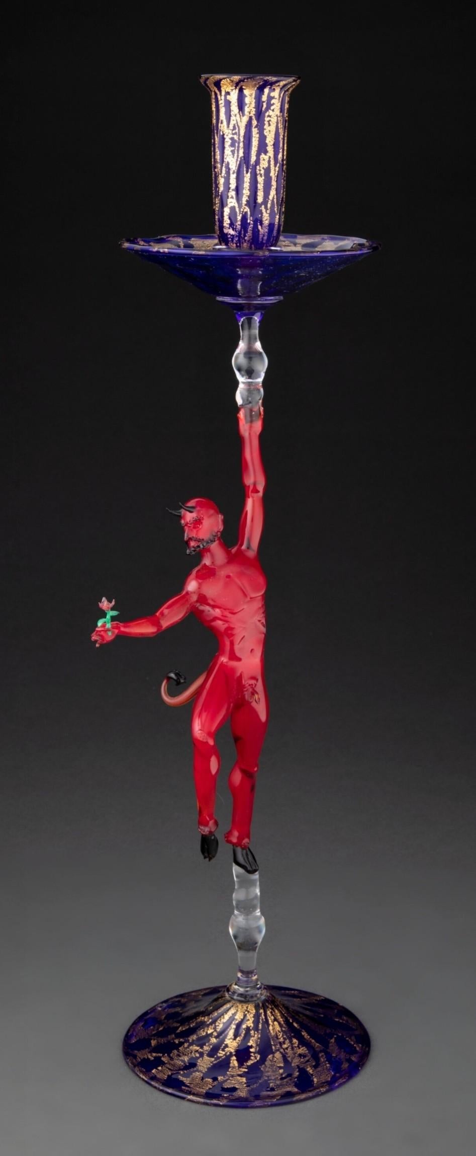 Rare chandelier en verre soufflé vénitien signé Lucio Bubacco (italien, né en 1957), daté de 1994, représentant un diable rouge avec une rose, d'une exécution exceptionnelle.

Le chandelier sculptural visuellement saisissant en verre cobalt avec