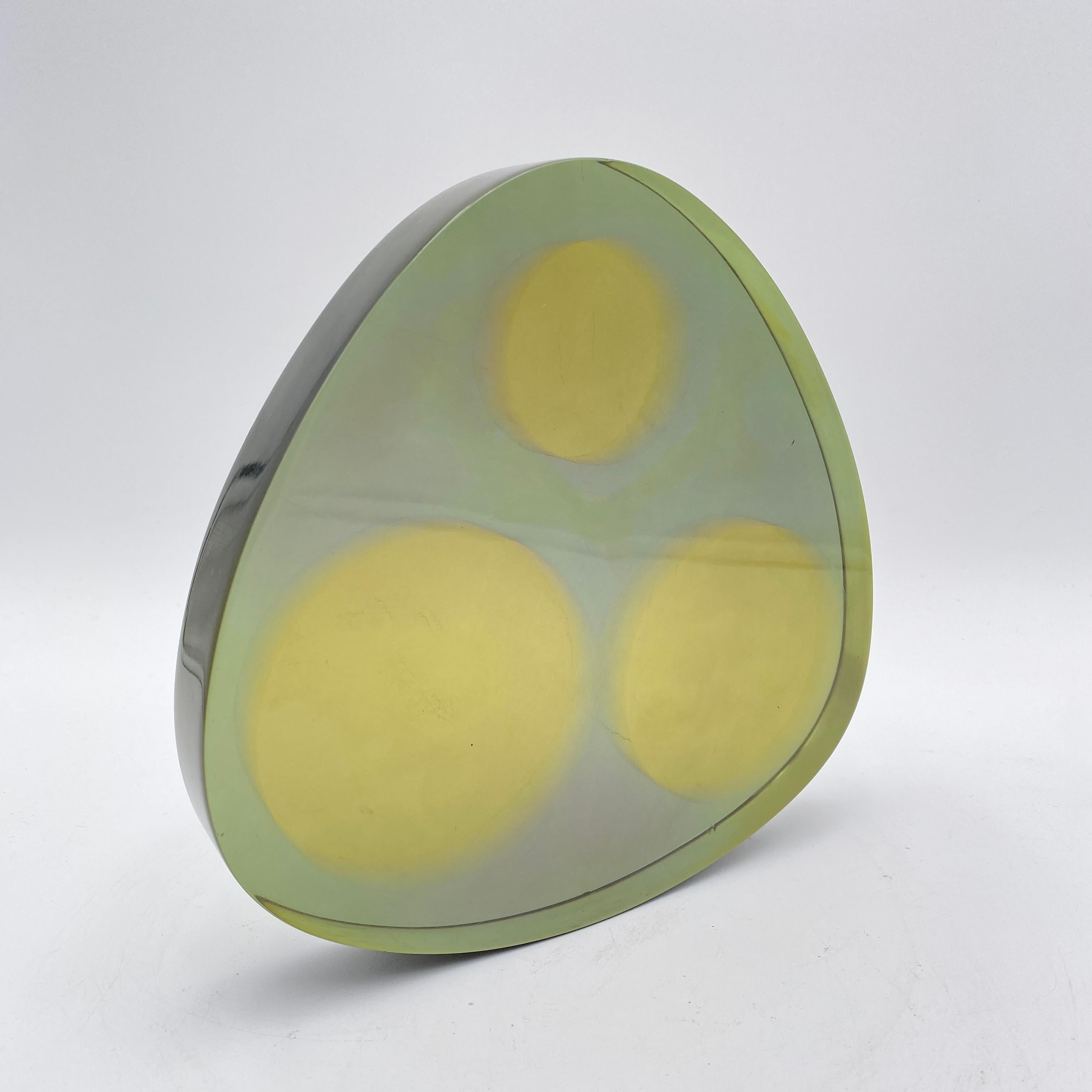 This is a unique lucite art sculpture with a post-modern design. Three yellow circles are trapped within a 1 1/4” thick transparent lucite mold. Unsigned. 