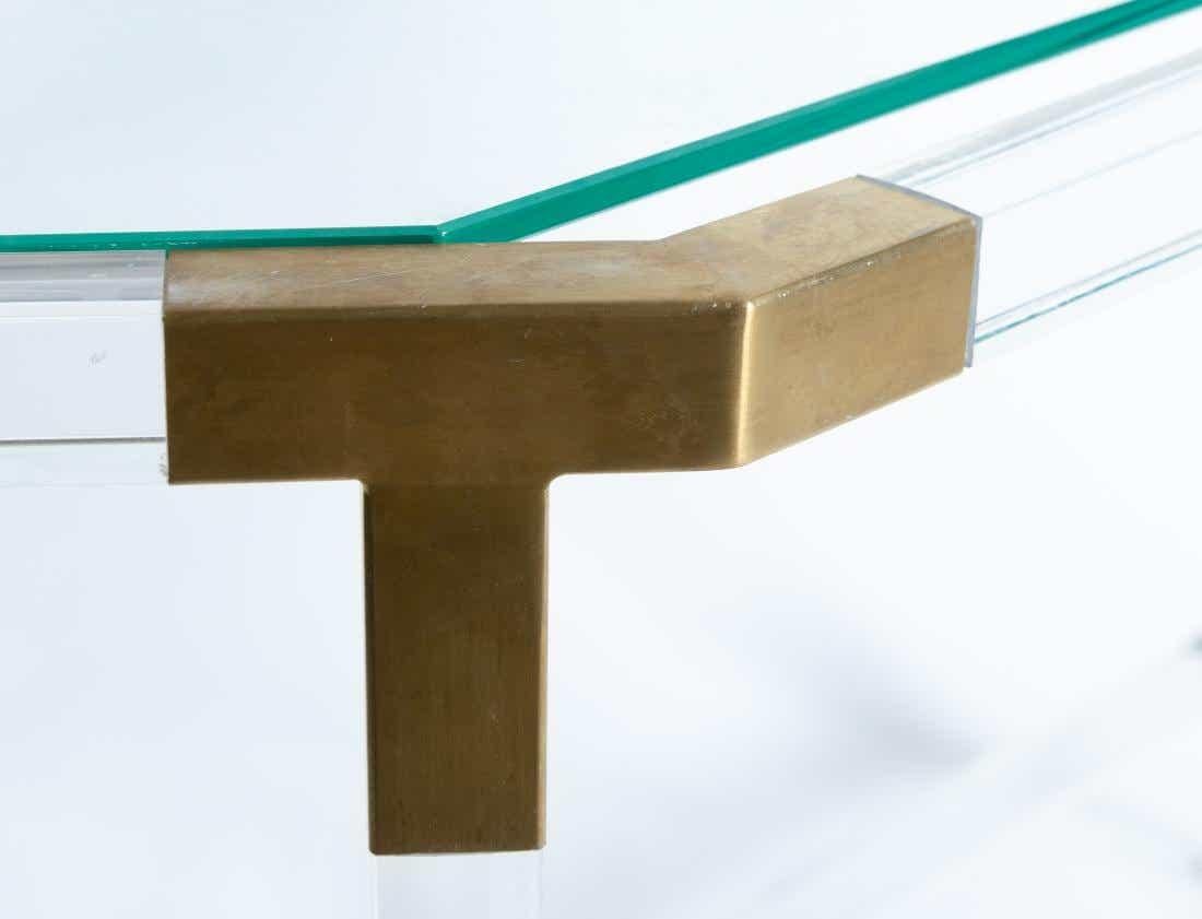 Charles Hollis Jones style lucite / acrylic brass Hollywood Regency style console table. This clear console table or sofa table features acrylic or Lucite frame with a top and bottom shelf. Acrylic or Lucite Legs, sides and joints with brass joints