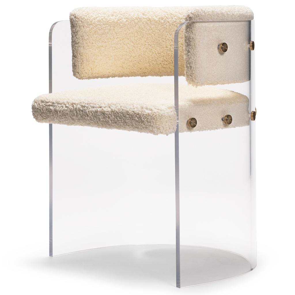 The Anhele dining chair with its 70's futuristic styling has a crystal clear Lucite/Plexiglass/Acrylic shell with a bouncy cream boucle seat and backrest.  The pieces are joined together with polished brass bespoke fixings. These chairs would make a