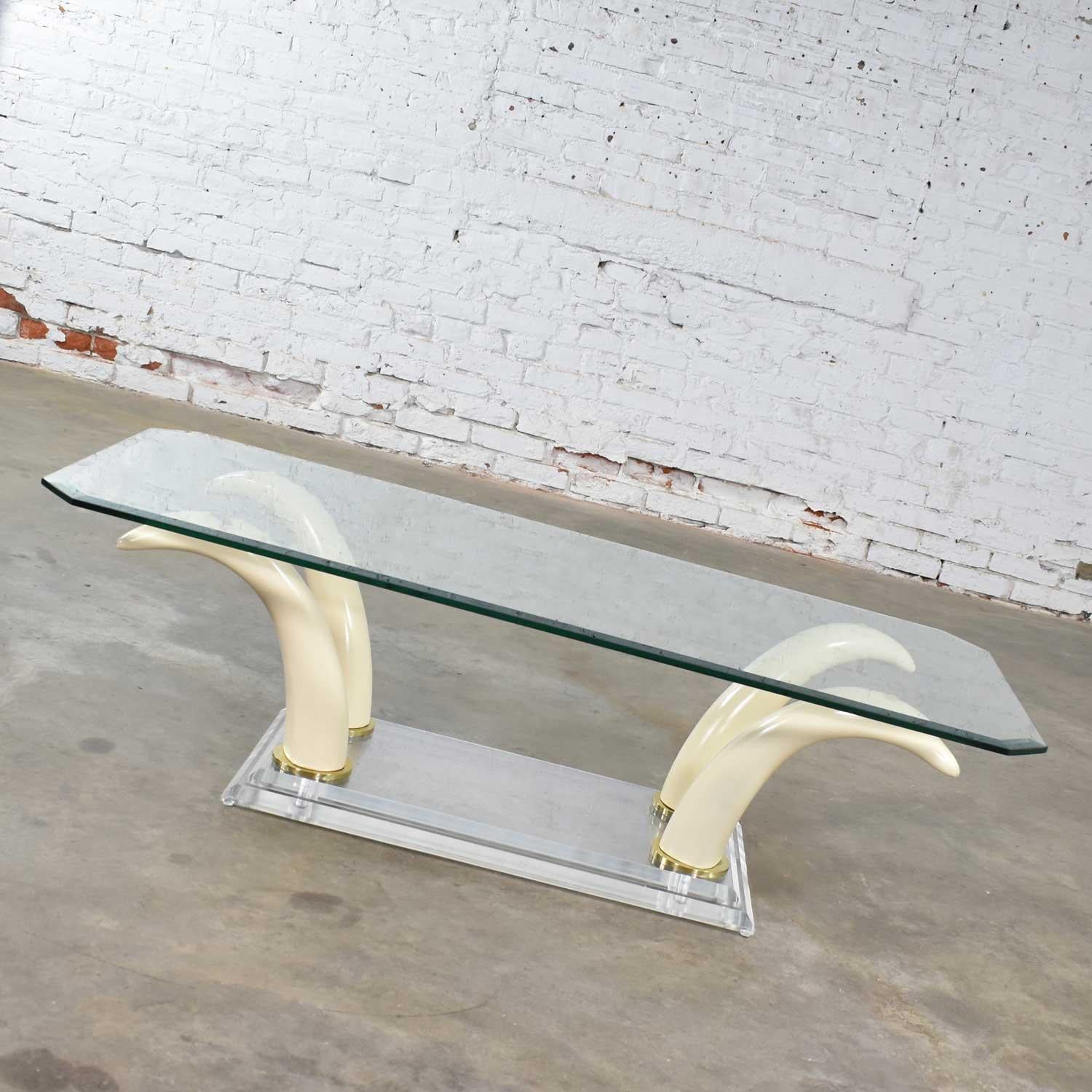 Uniquely handsome Hollywood Regency coffee or cocktail table with Lucite and acrylic faux tusk base and glass top in the style of Maison Jansen for Ralph Pucci or Italo Valenti. It is in wonderful vintage condition with no outstanding flaws. There