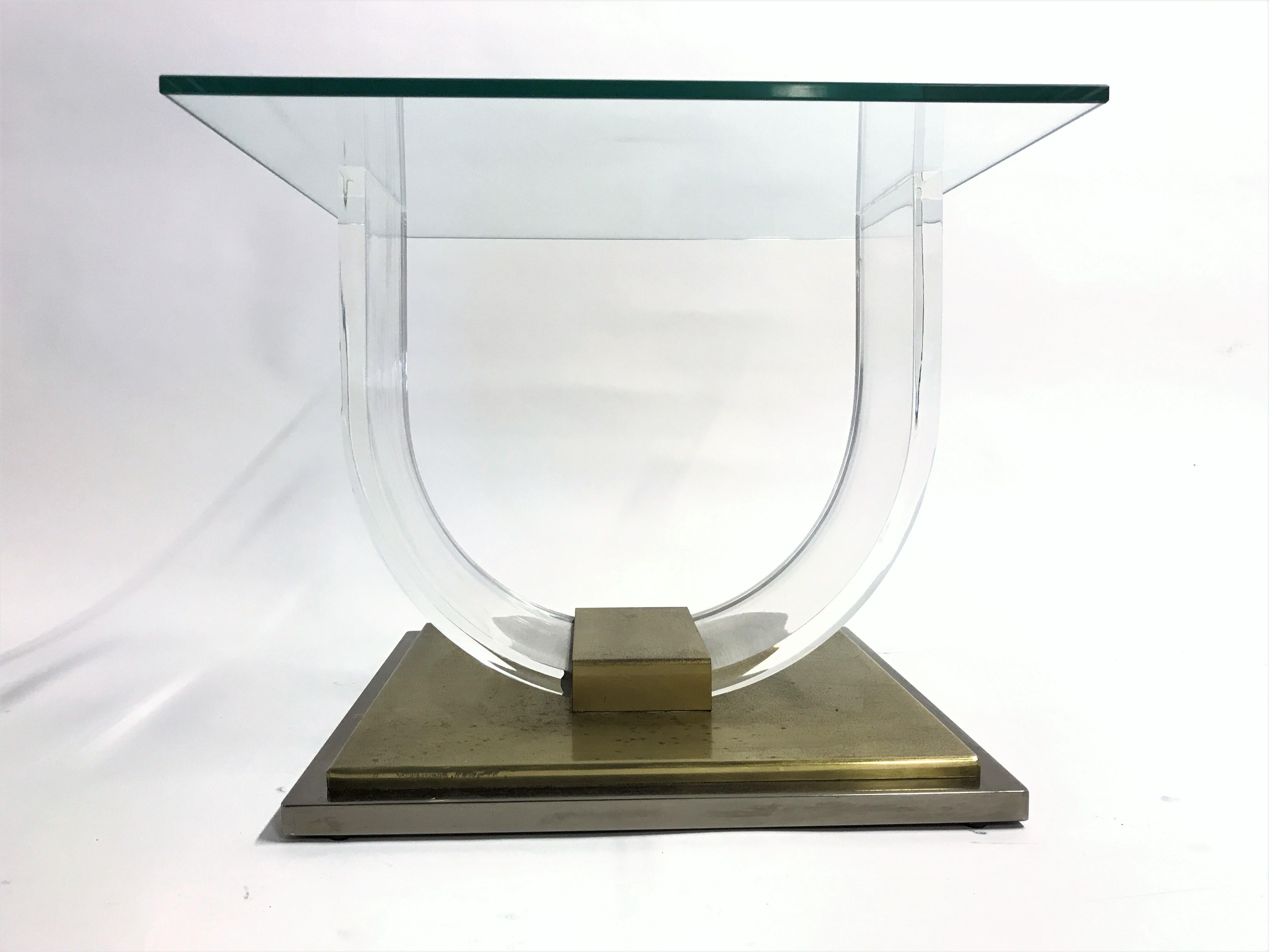 'arch' coffee table with a square glass top in the style of Charles Hollis Jonis and made by Belgochrom.

Made from a Lucite frame mounted on a heavy brass base.

Patina on the brass.

Good condition.

1970s - Belgium

Dimensions:
Height