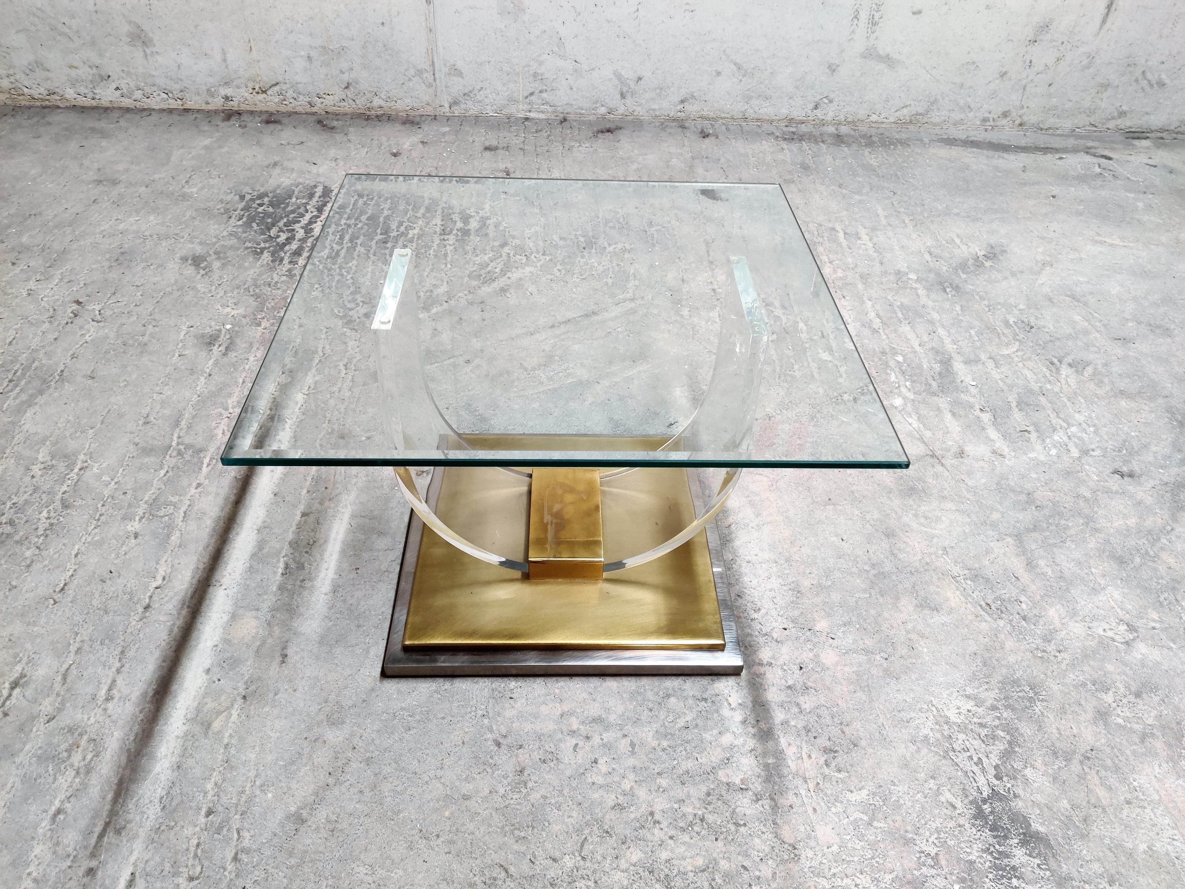'Arch' coffee table with a square glass top in the style of Charles Hollis Jonis and made by Belgochrom.

Made from a Lucite frame mounted on a heavy brass base.

Patina on the brass.

Good condition.


1970s -
