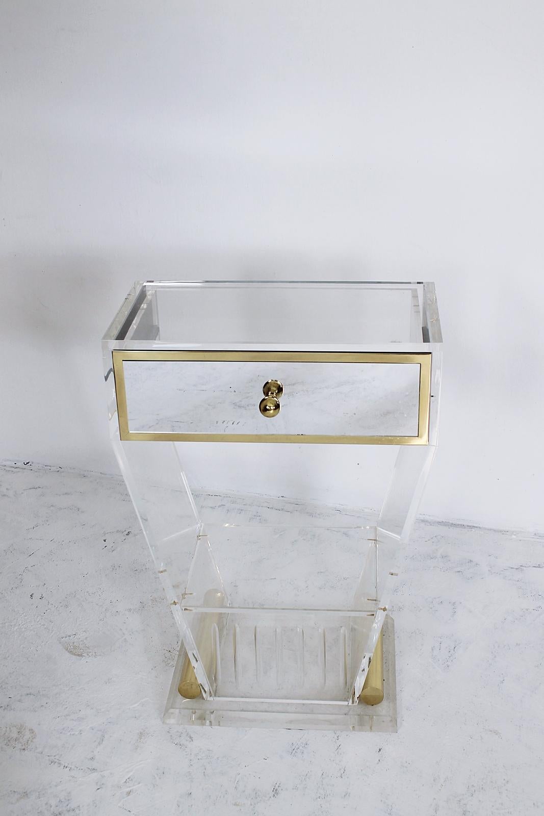 This lovely Lucite small entry console features a mirrored drawer with a brass drawer pull and a shelf in the lower part. 
This was made in France and dates from the 1970s.
 The condition is very good for its age, with no real damage to be seen,