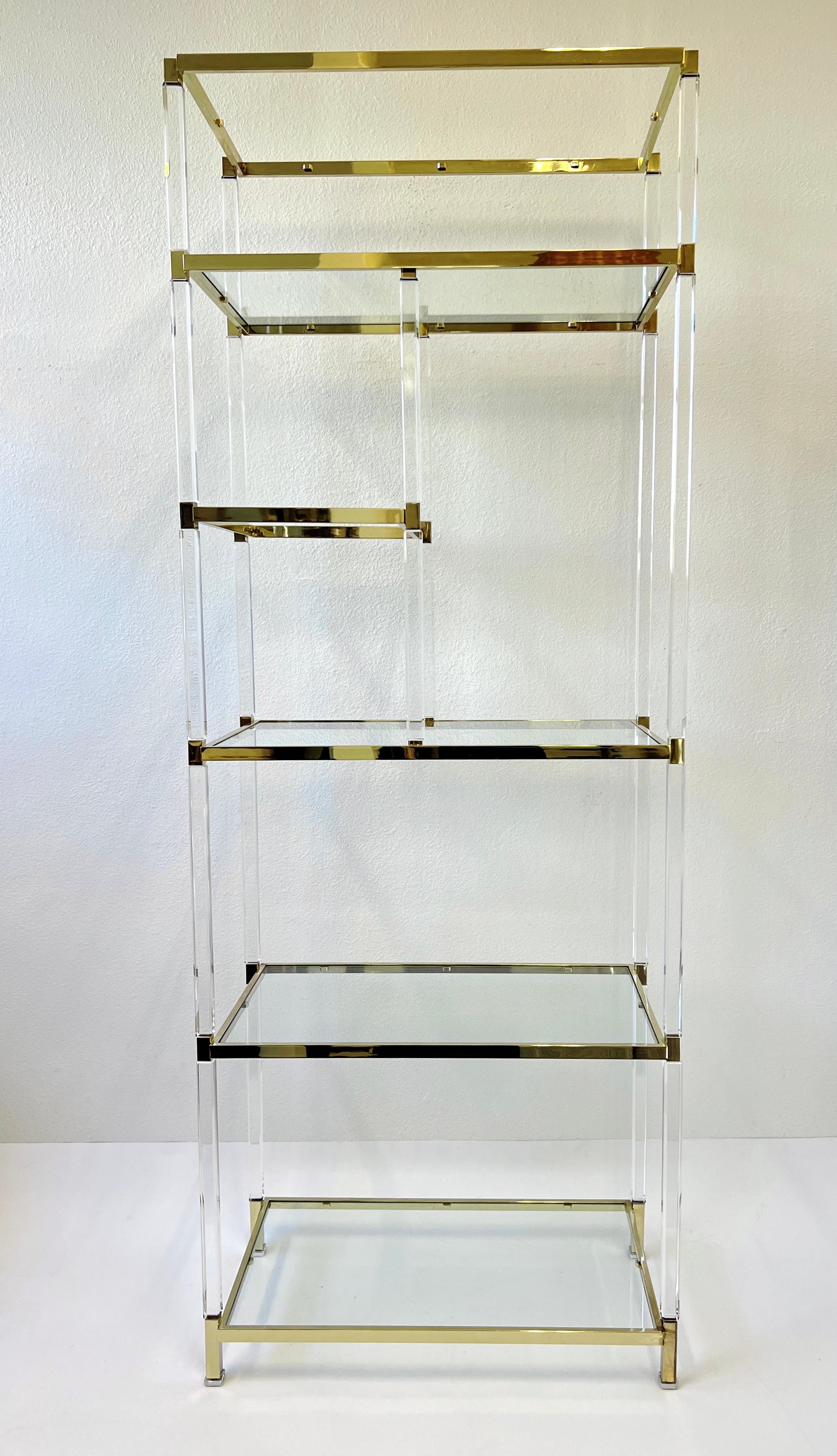 Glamorous 1960’s clear lucite and polish brass with glass shelves etagere by American renowned designer to the starts Charles Hollis Jones. 
Part of the ‘Metric Line’ designed for Hudson Rissman in 1966. 
Can be used to separate a room or display