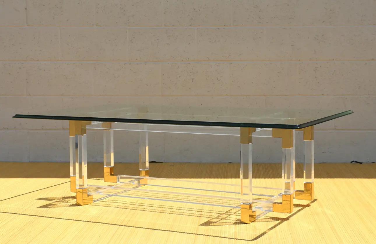 Spectaculaire table basse vintage en acrylique et laiton conçue par Charles Hollis Jones. Cette publication date des années 1970. Cette magnifique table basse fait partie de sa collection 