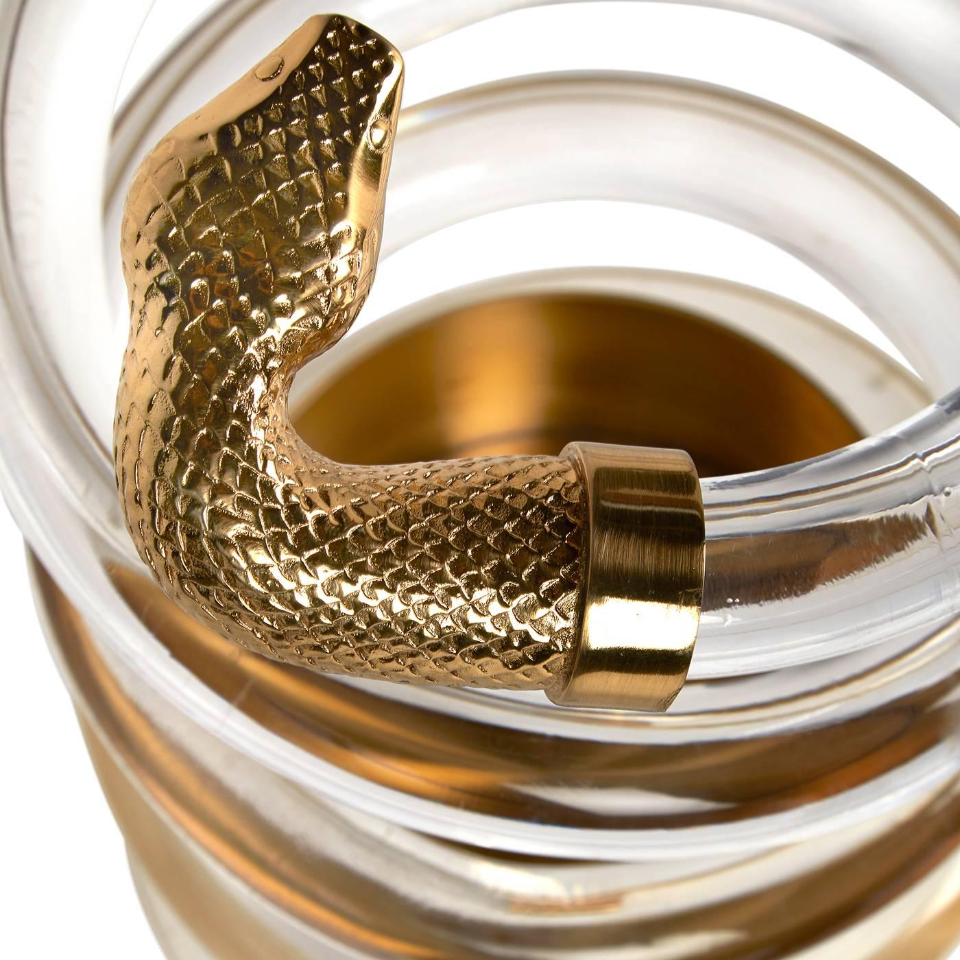 Reptilian receptacle. Twinkly acrylic coils weightlessly from a solid brass base and is capped with a brass serpent head ready to strike. Edgy glamour meets serpentine undulation for the ultimate in umbrella sophistication. The original reptilian
