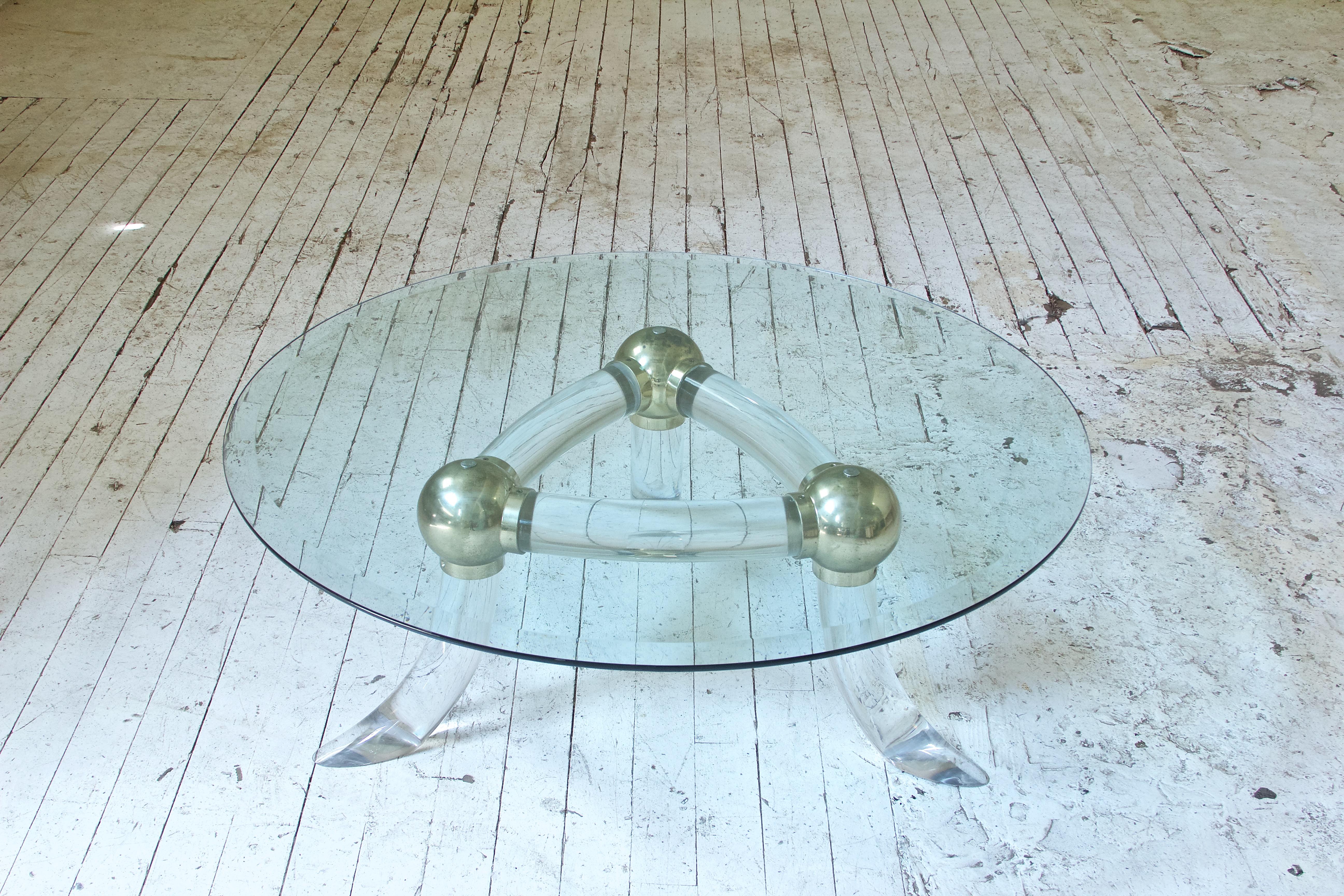 Playful little table in Lucite and brass with three splayed 