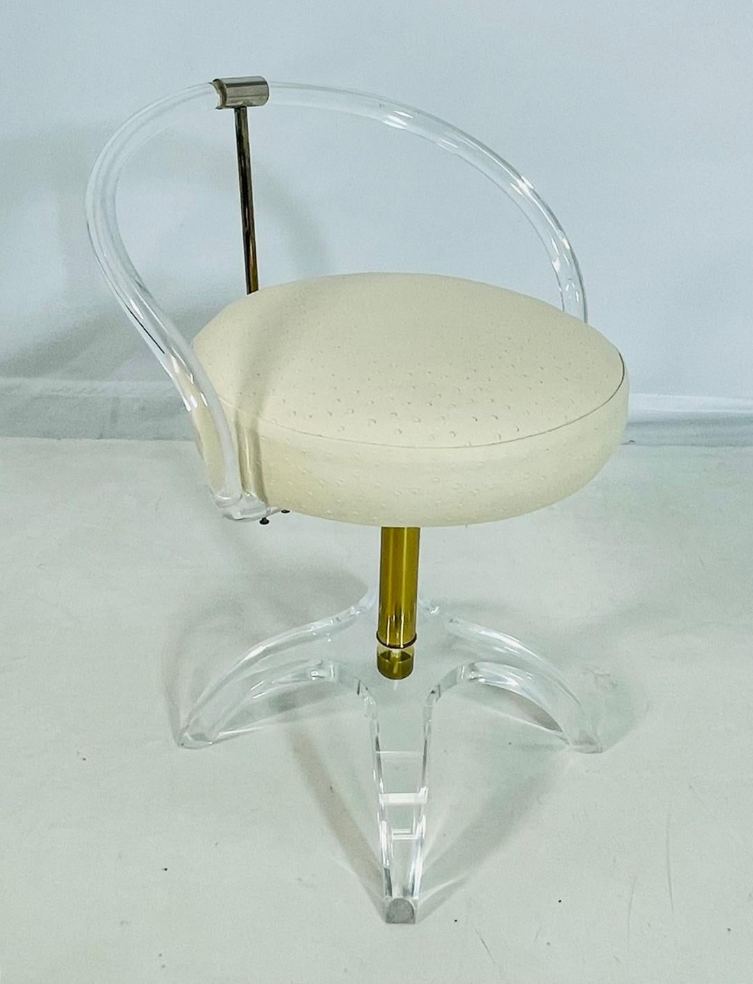 Stunning Lucite and brass vanity chair designed by Charles Hollis Jones, the original and first design was in brass and commissioned by Lucille Ball, and upholstered in white vinyl fabric. 

The chair is upholstered in leather with ostrich embossed
