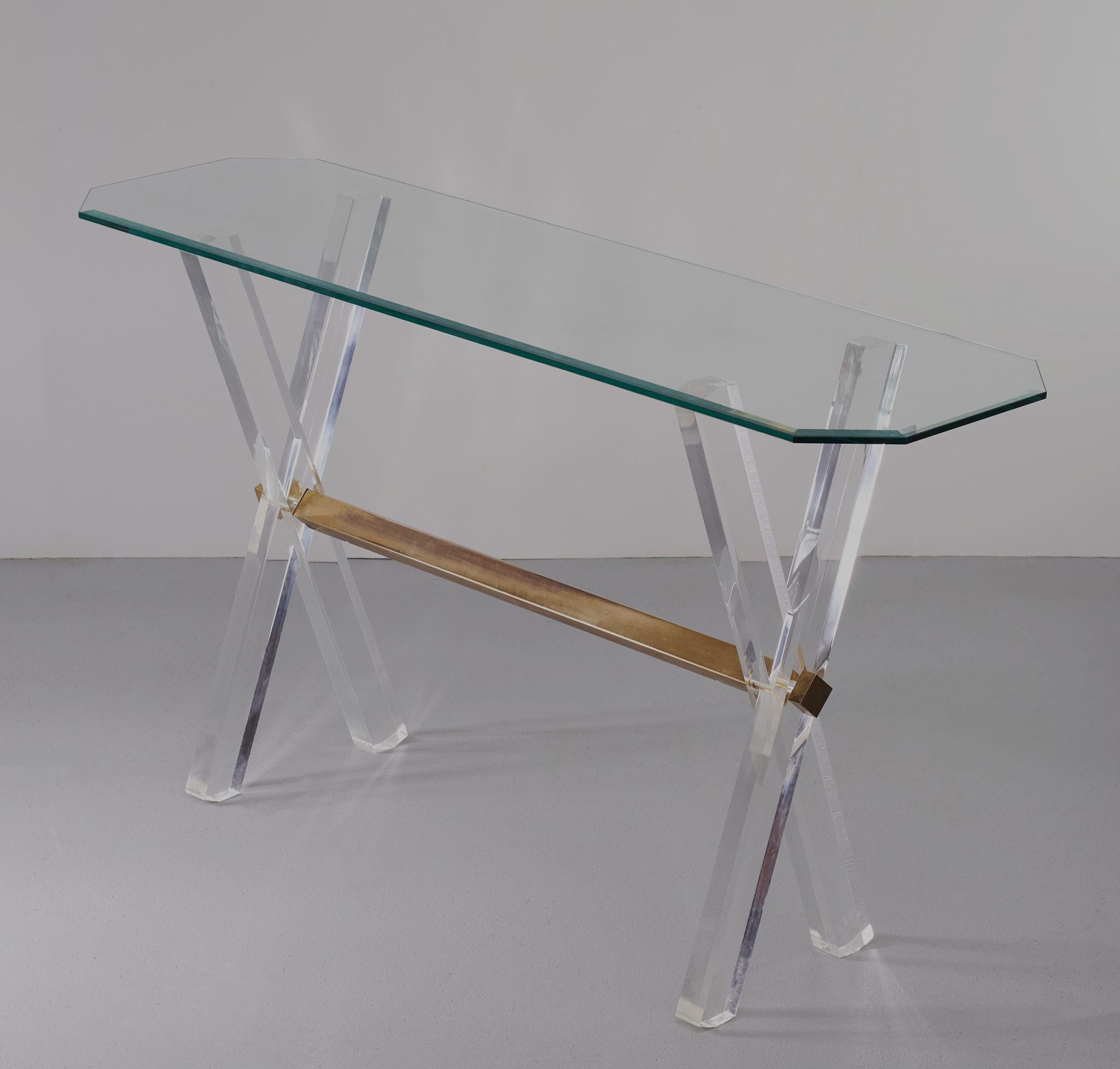 Very nice x frame Console table Lucite base connect it by a Brass 
Bar. Beveled Glass top. Hollywood Regency in style.
Small damage on one side of the leg. ''See photo ''. Otherwise in very 
Good condition.