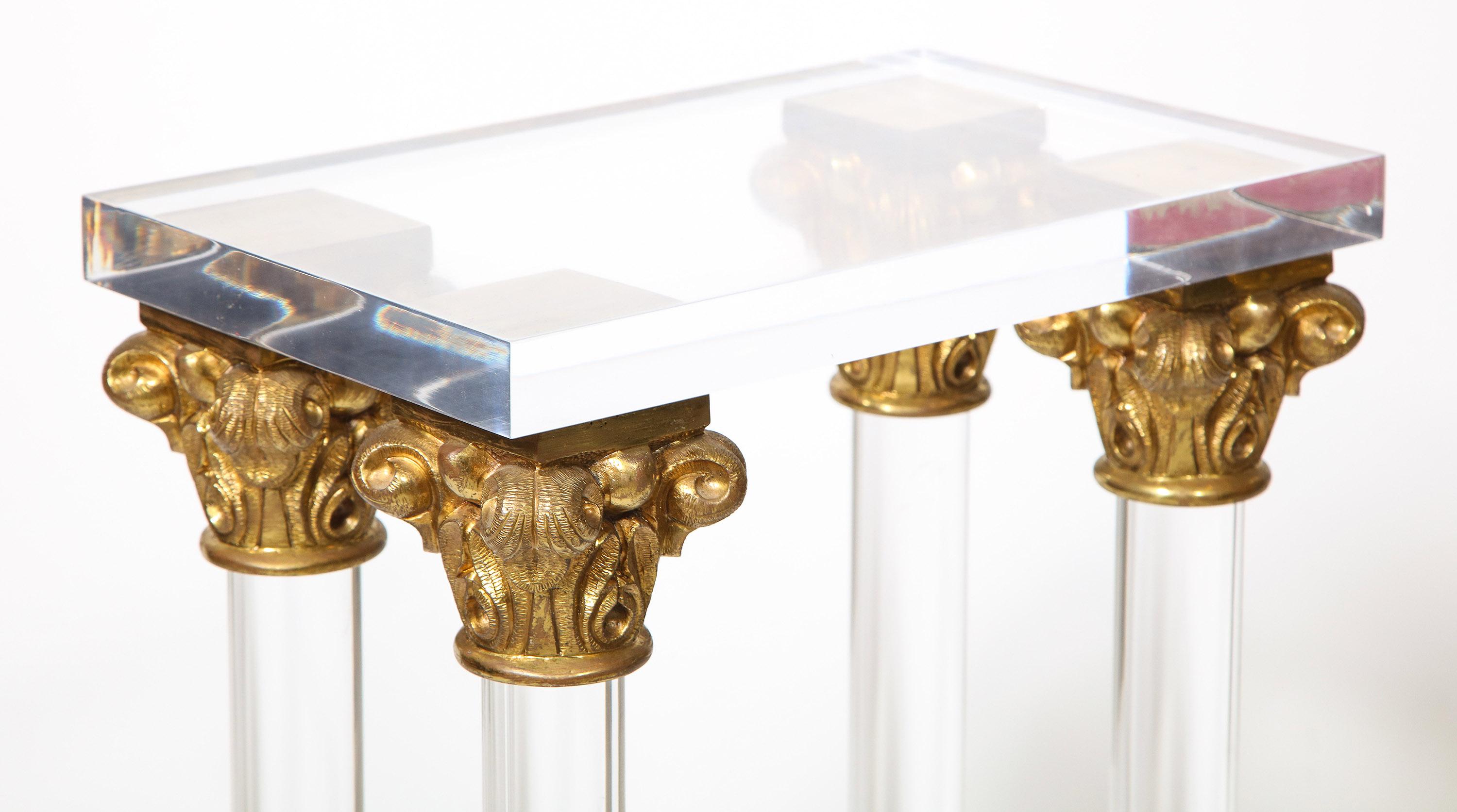 Lucite and bronze console table, Attr: Maison Jansen

The glass topped console supported by two pedestals, each composed of a lucite block base supporting four lucite columns with finely cast bronze Corinthian capitals at top and a bronze stepped