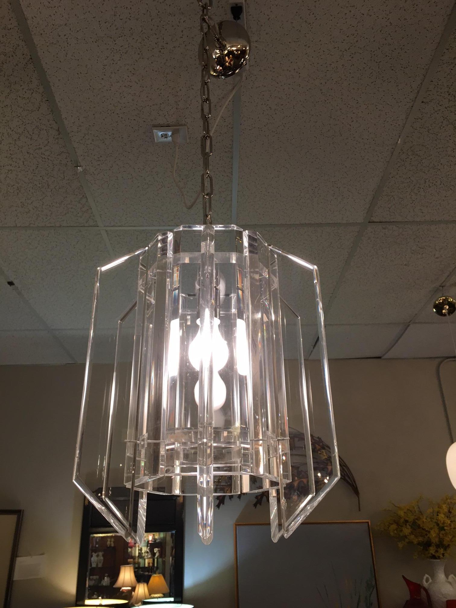 This Lucite midcentury chandelier is a restored midcentury piece. The aging chrome was replaced with new canopy and chain. The Lucite itself is in remarkable condition with practically no scratches. The chain is 60