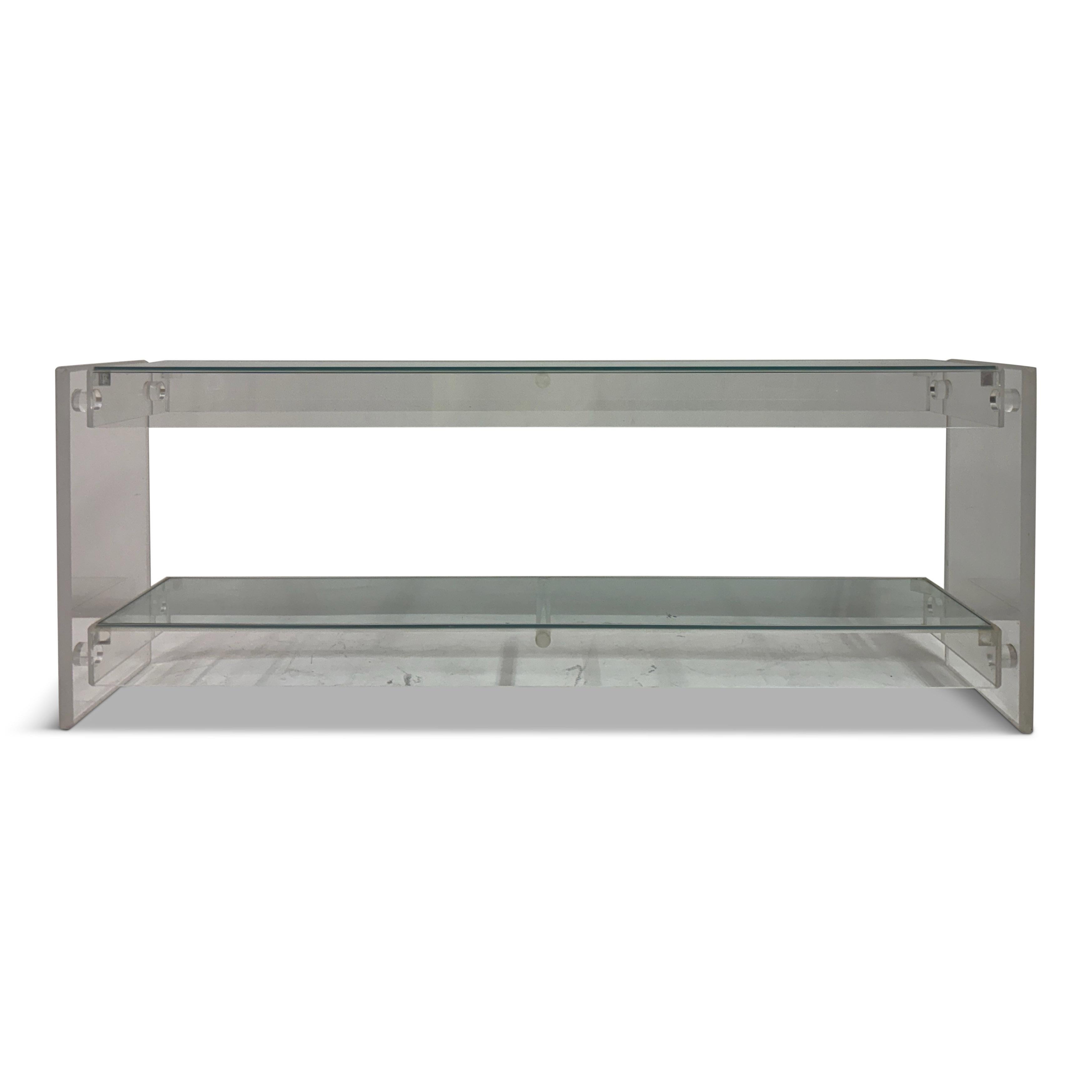 Console o pensile in lucite e vetro, America, anni '80 circa

Consolle elegante e minimale in lucite e vetro, americana, anni '80 circa, composta da spessi pannelli laterali in lucite lucida uniti da due livelli di scaffali in vetro galleggianti. La