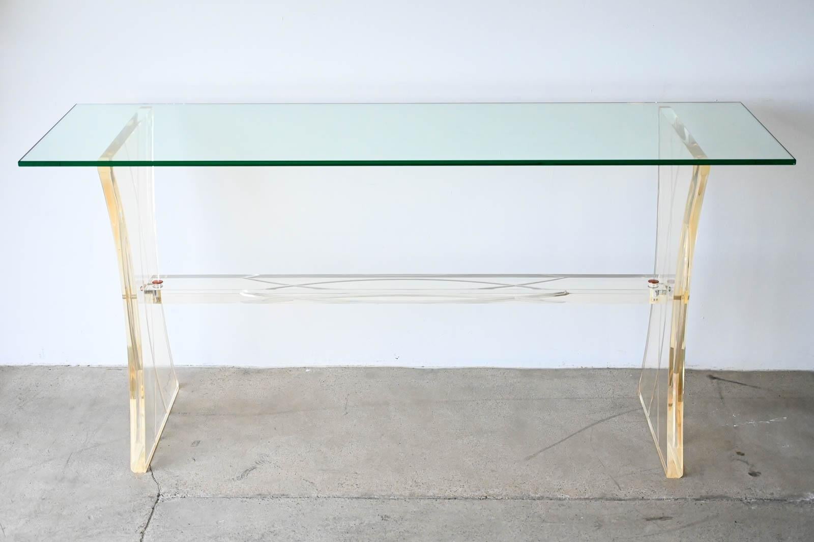 Lucite and Glass Console Table, ca. 1980.  Beautiful thick lucite base with metal detail and carved design with cut glass top.  All original in very good original condition 8/10.  Glass sits on base and is easily transported in two pieces.

Measures