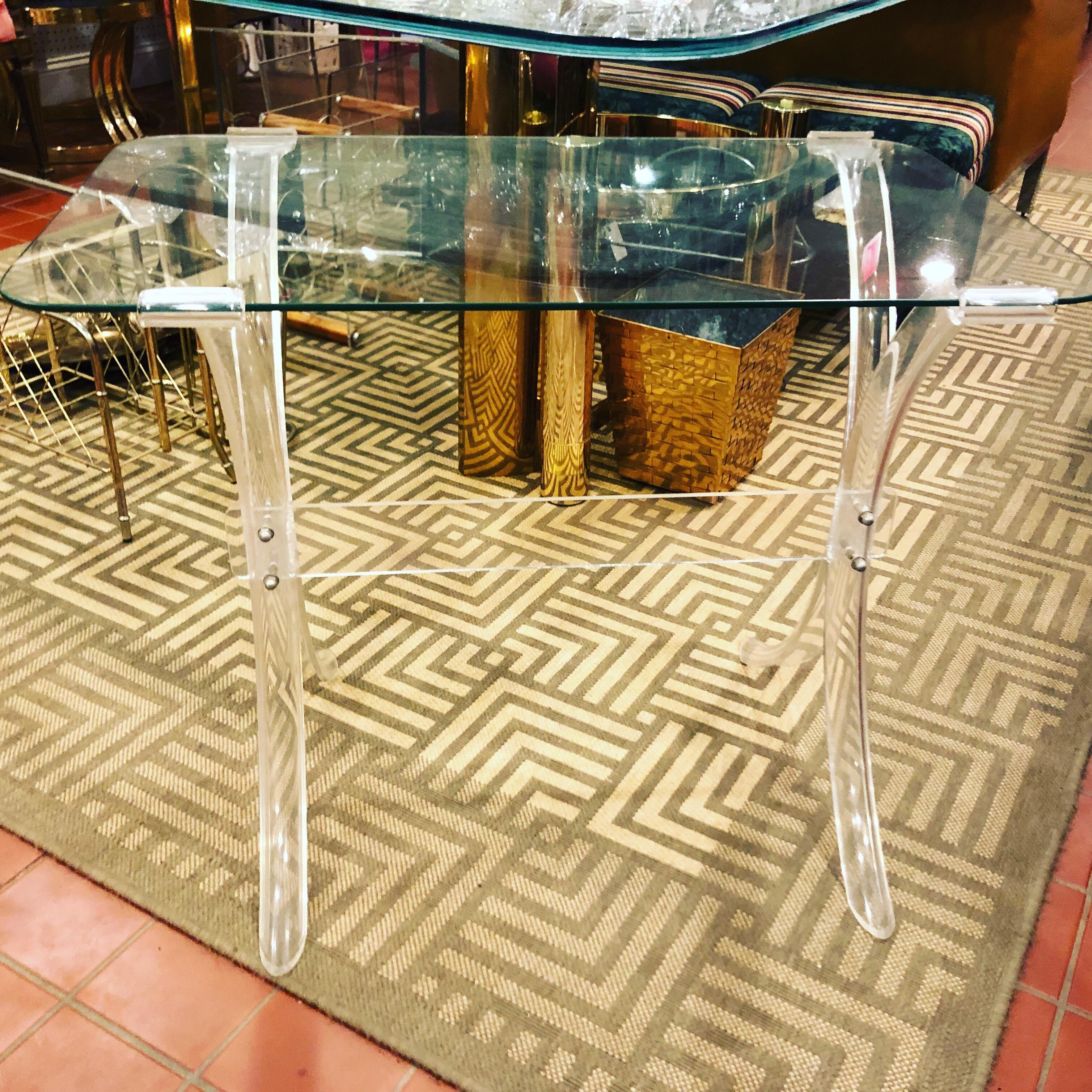 Lucite and glass side table in the manner of Charles Hollis Jones. Glass tray style top with lovely Lucite frame and legs. Adorned with round chrome/metal studs or screws. Perfect for serving tea or using as a liquor table.