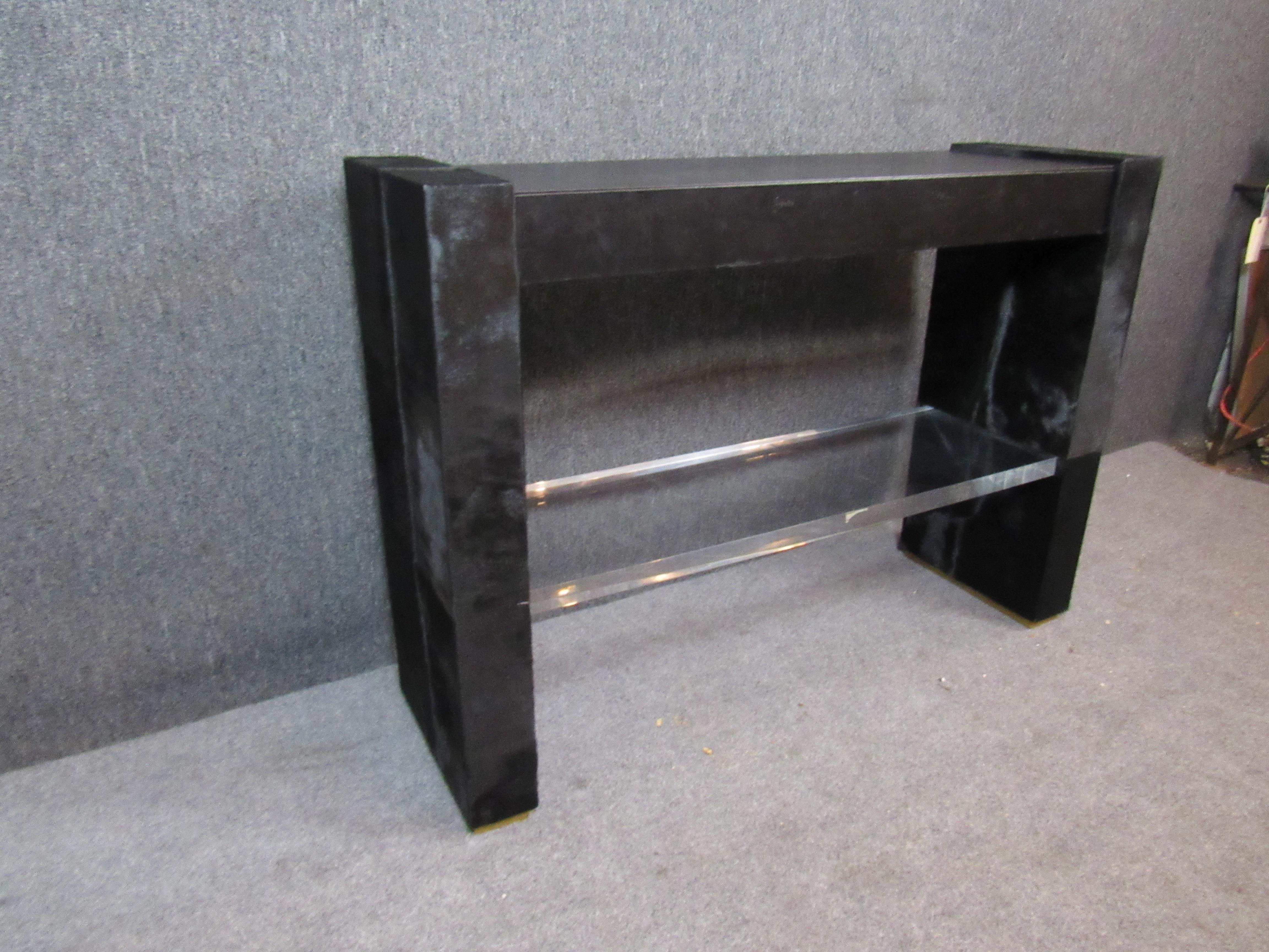 Absolutely unique post-modern console with a striking horsehide covering, leather & brass accents, and a crystal lucite shelf. A large pull-out drawer provides additional hidden storage, perfect as a hallway table or even a narrow desk. The black