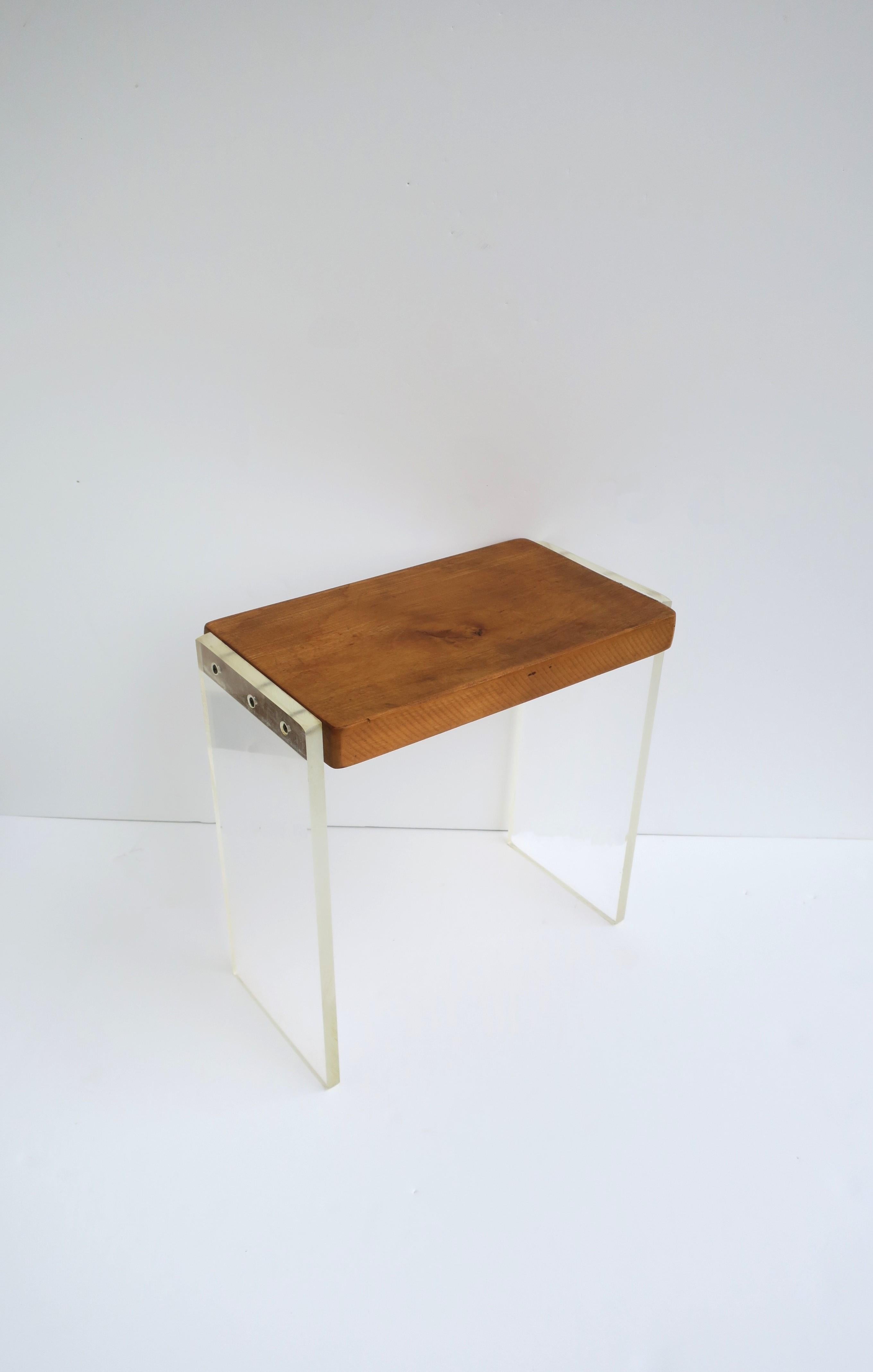 An oak and Lucite stool or small table, Post-modern design period, circa late-20th century. Piece is rectangular with Lucite legs and a thick oak top/seat. Oak is 1.25