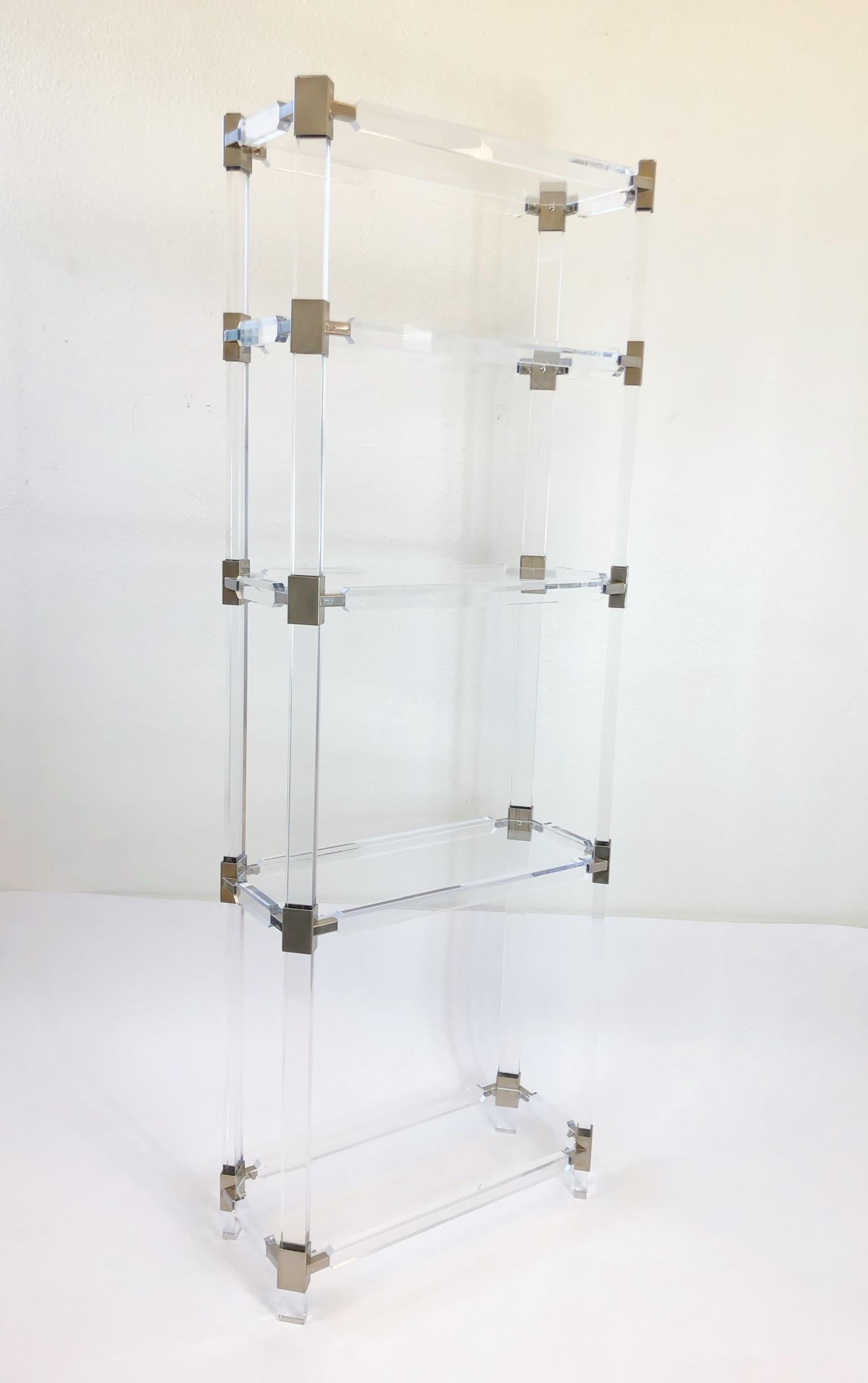 A glamorous clear acrylic and polish nickel étagère designed by renowned American designer Charles Hollis Jones for Paul Laszlo in the 1970s. The étagère is in original condition, so it shows minor wear and age. The étagère is signed by CHJ. The
