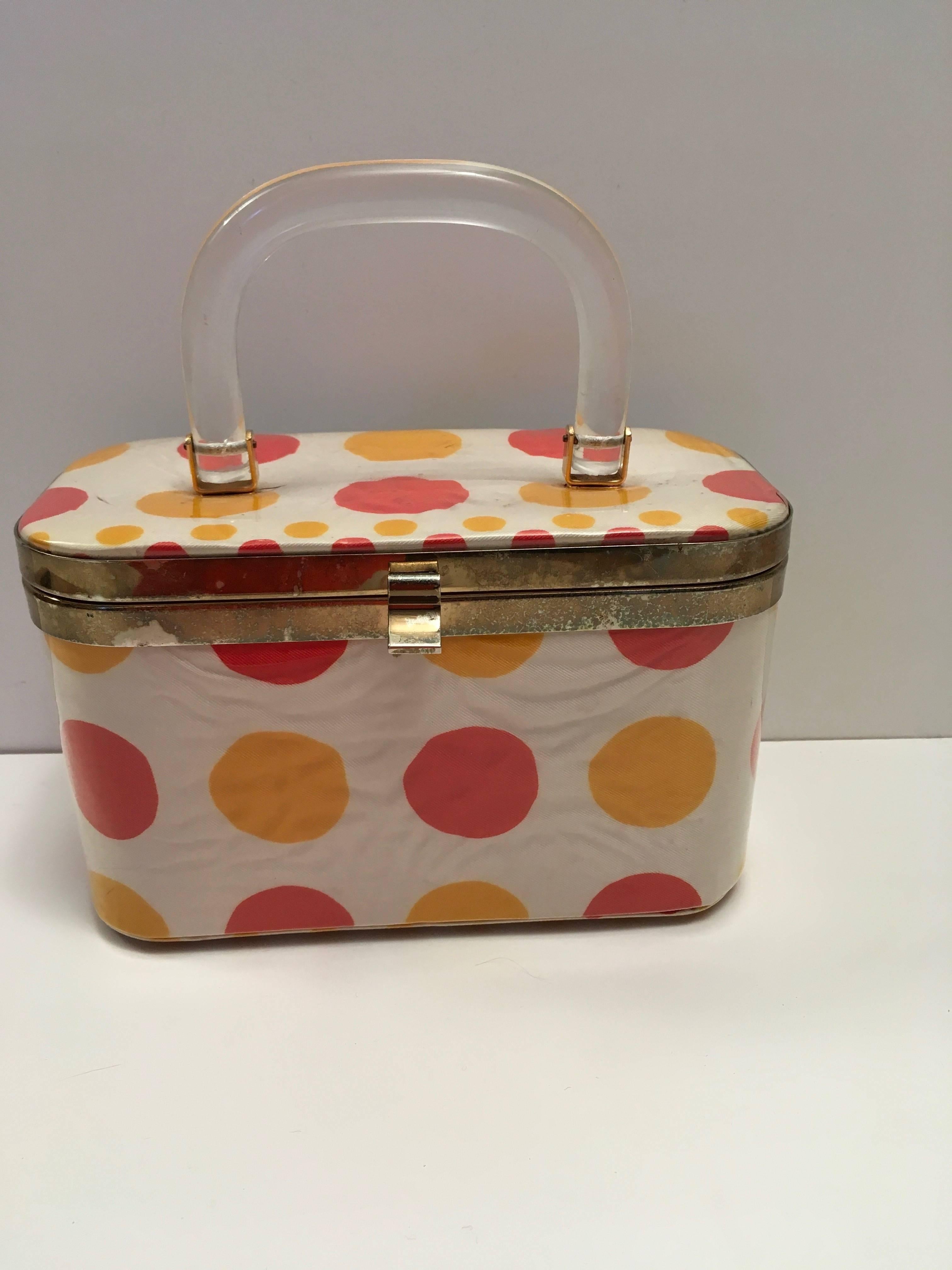 Presented here is a wonderful 1060's fun, happy, everyday purse. The purse is a creme silk fabric with polka dots measuring 1.24 inches in diameter.  They are covered with a sheer plastic coating.
The wonderful lucite handle measures  9.5 inches.