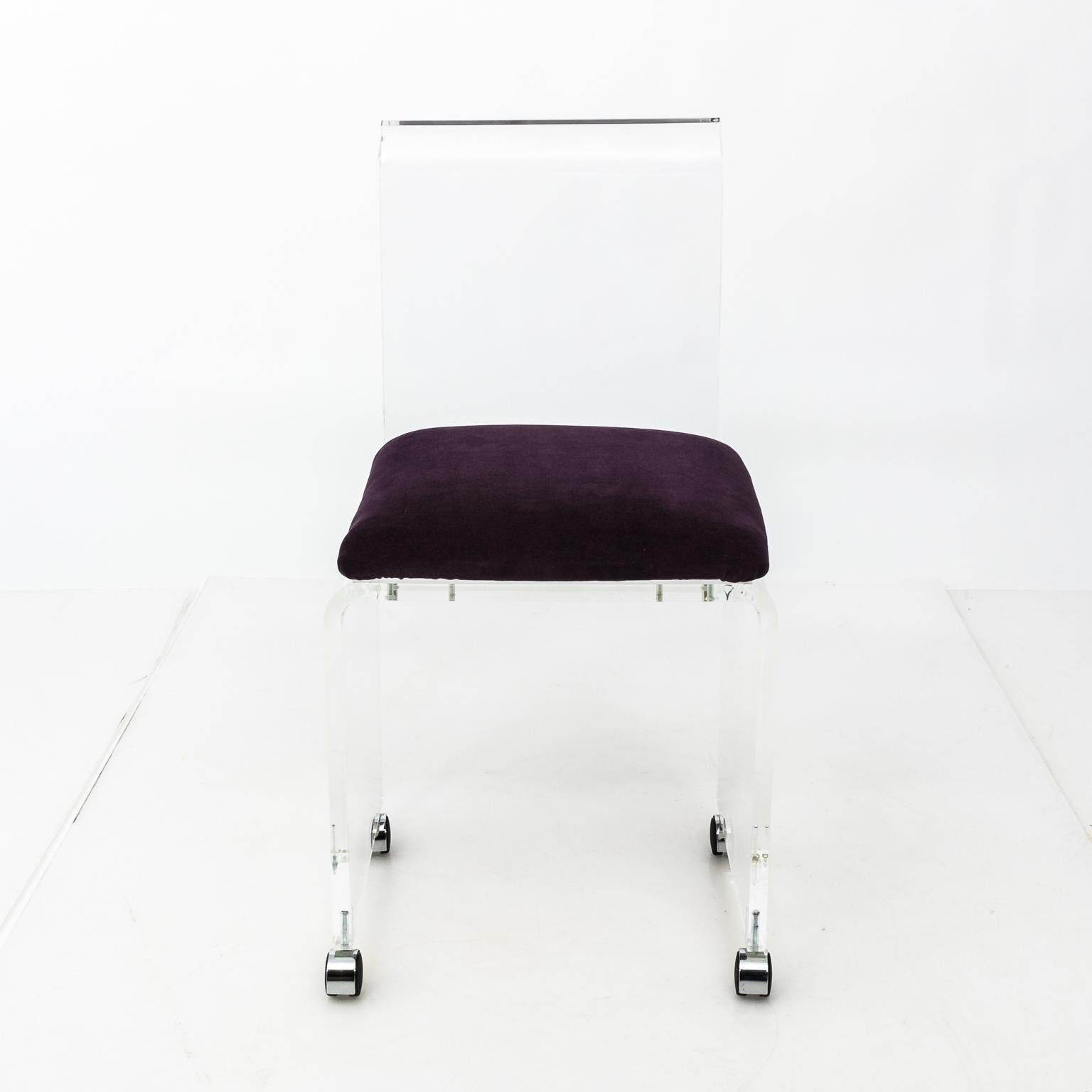 Lucite vanity chair on casters with purple velvet seat.