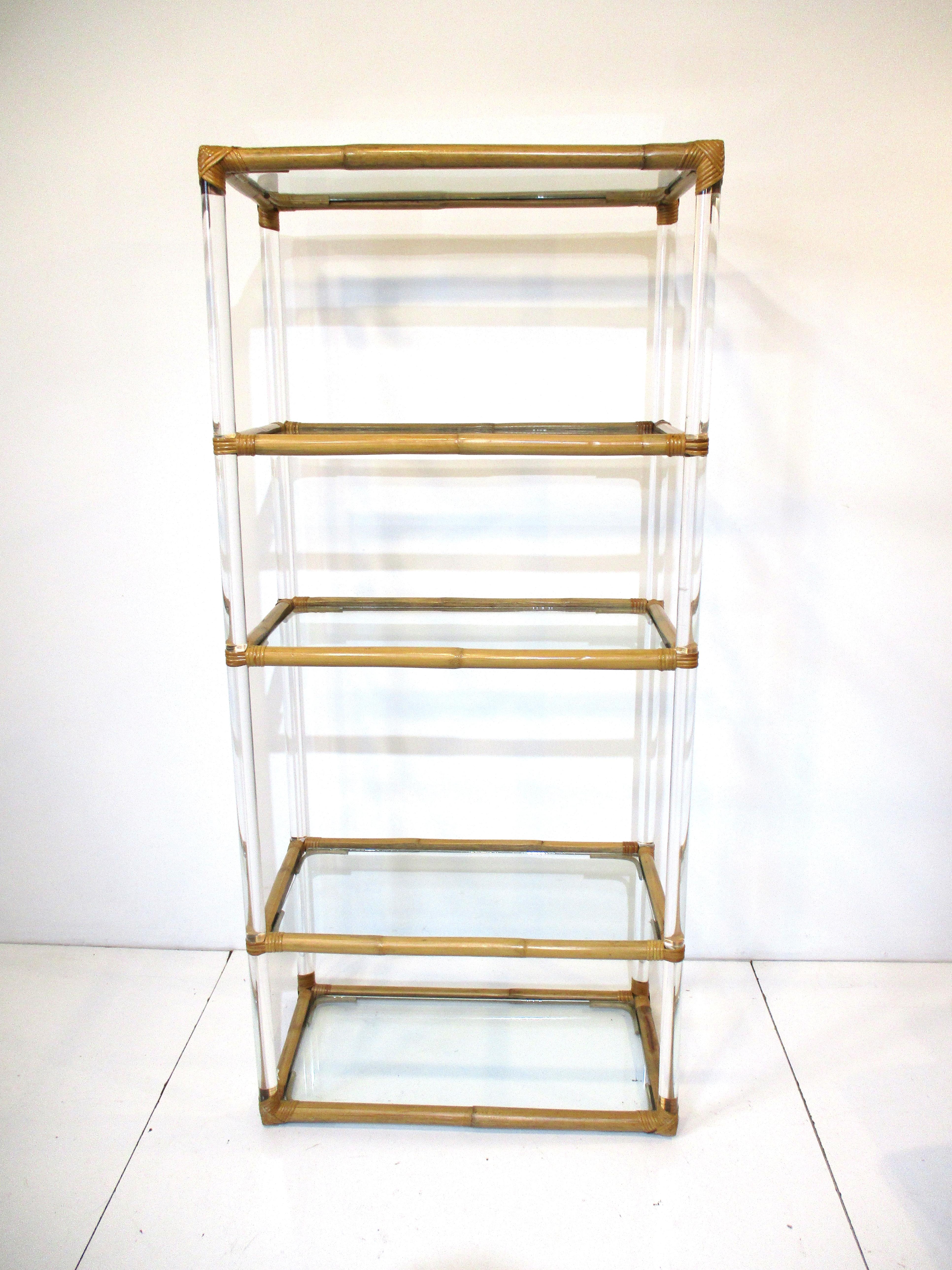 A very well crafted Etagere with clear Lucite posts straddled by hardened bamboo pieces woven to each corner making for nice detailed construction . Five glass shelves that include the top and bottom give the piece a lot of display space ,