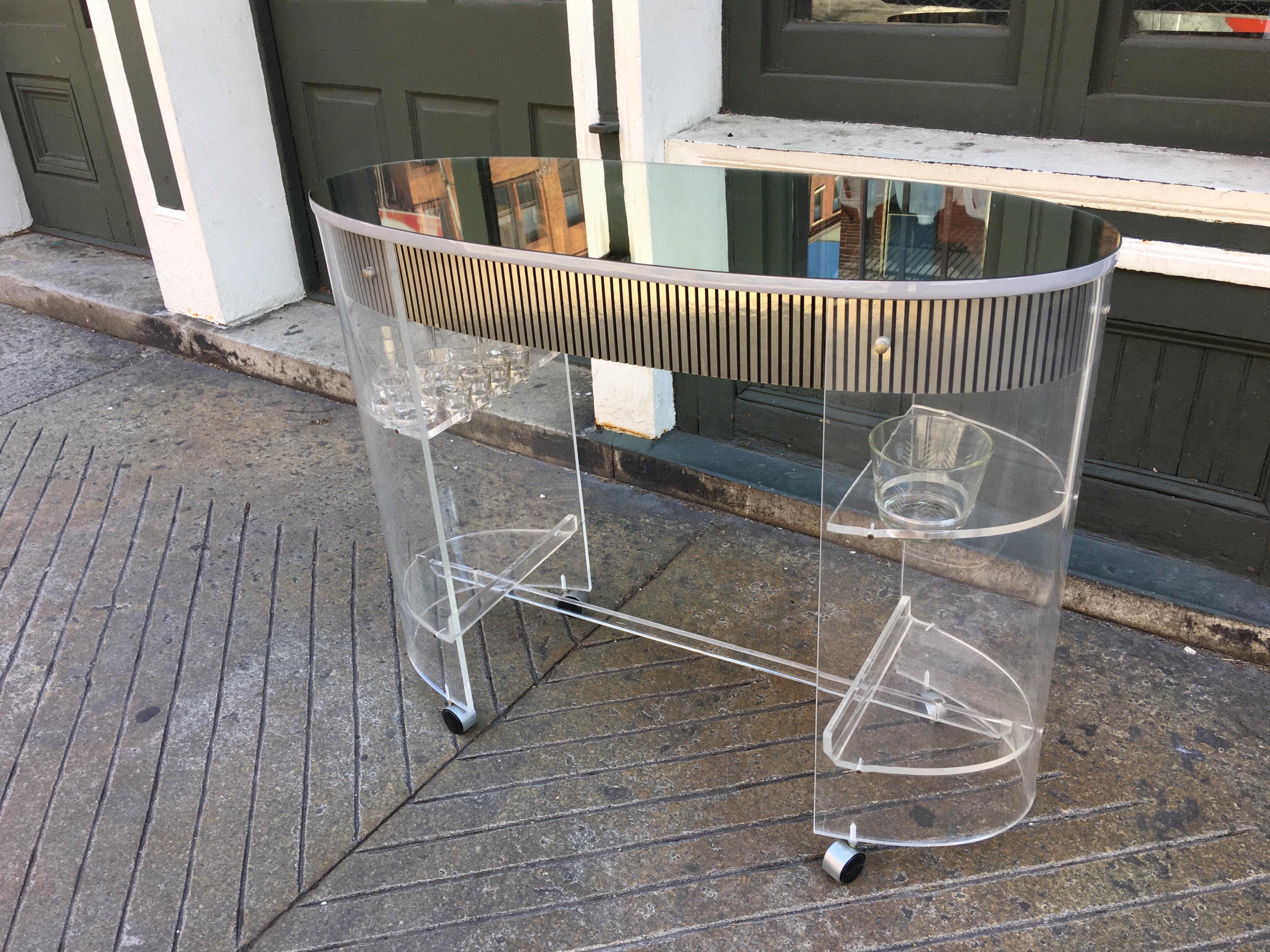 1970s Lucite bar with 2 stools. Set includes original set of bar glasses (12) and 1 glass ice bucket. One stool shows crazing on top of seat, but structurally solid. Might be nice to add 2 thin round cushions to tops of stools! One pullout /