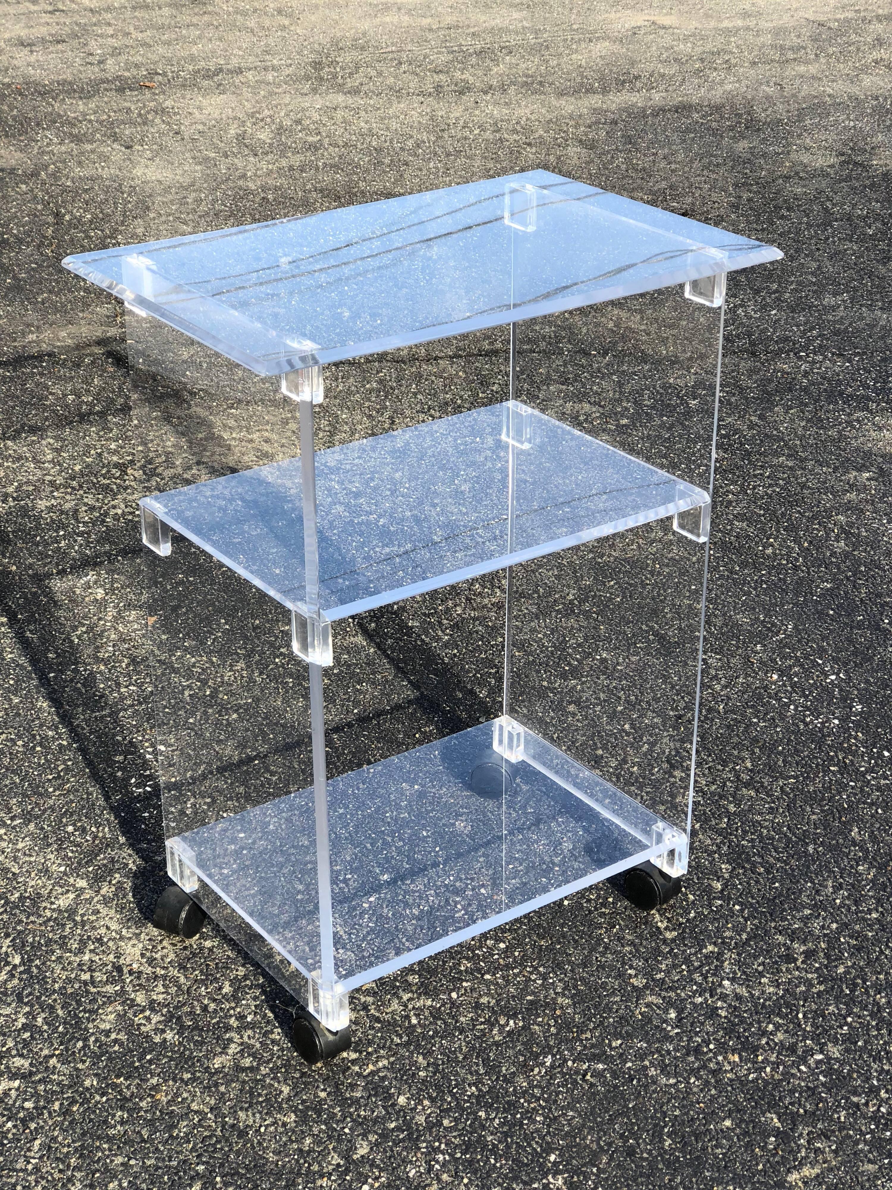 Lucite Bar Cart on wheels. It has three nice, thick shelves for ample storage. It also has castors to roll from room to room . Ideal for that small apartment or living room.