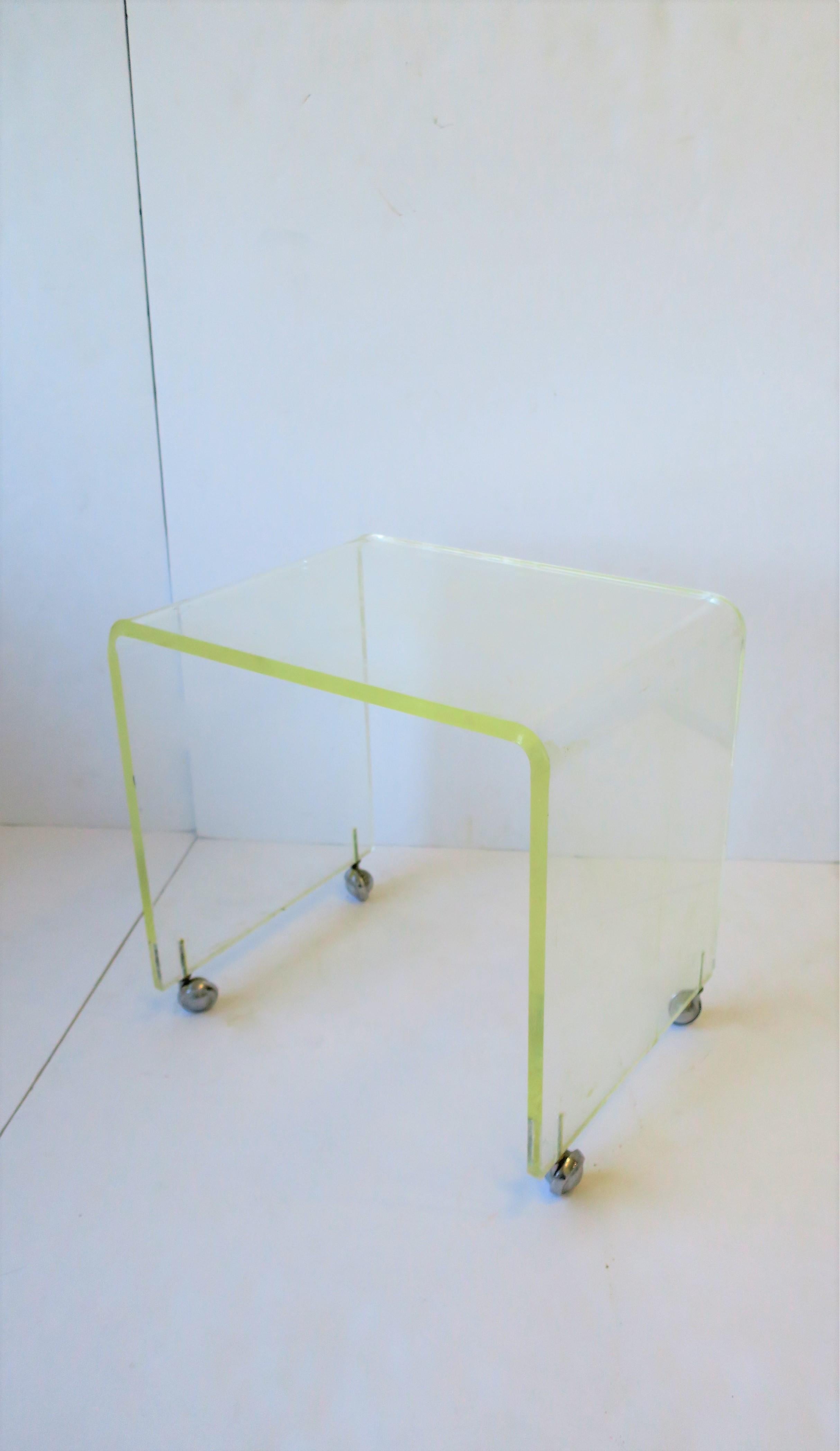 A vintage Modern Lucite bench with 'waterfall' edge on chrome caster wheels, circa 1960s. Piece is versatile; can be used as a bench/stool/vanity seat, or as a side or end table, etc. 

Piece measures: 12