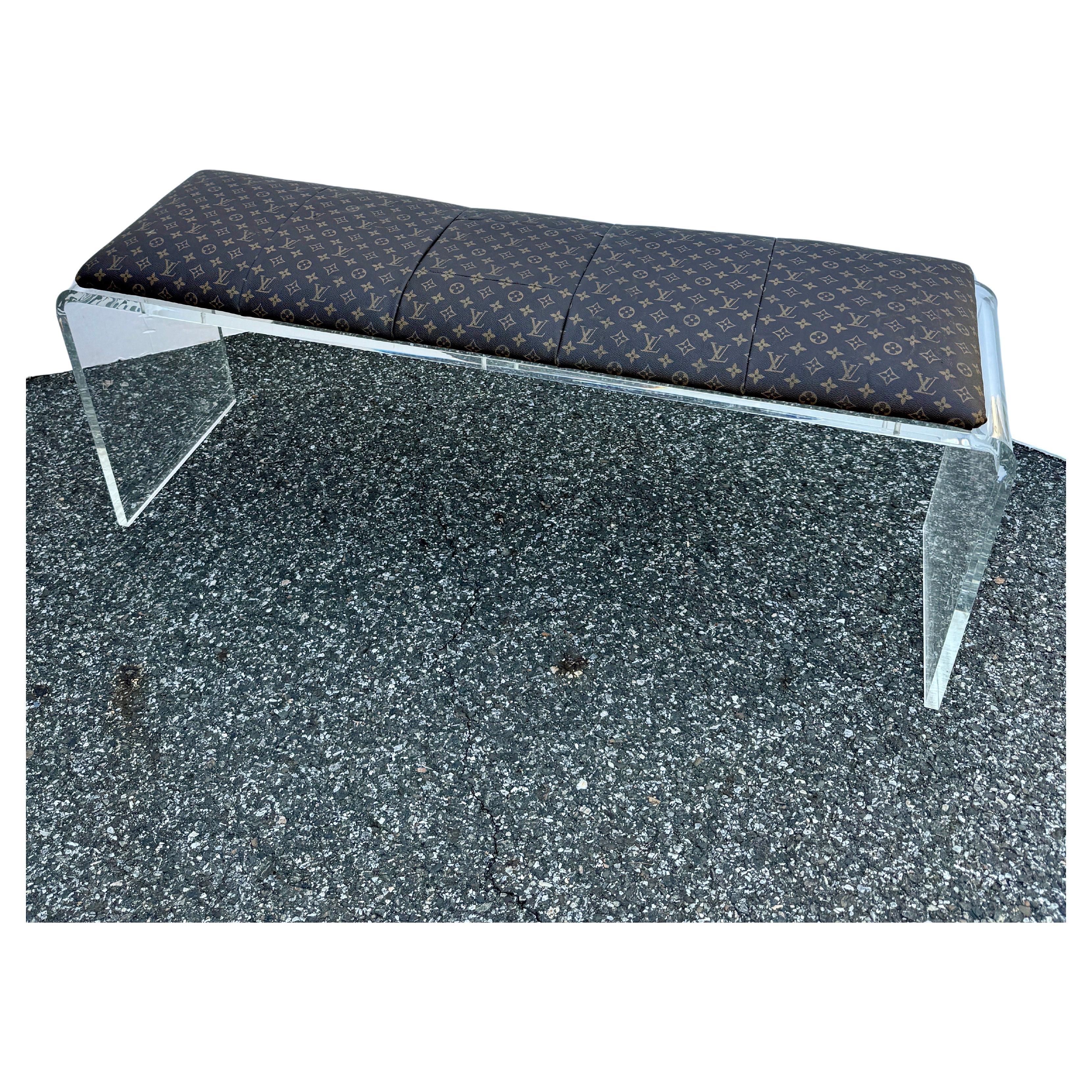 Design and purpose best describe this one-of-a-kind custom bench. This piece features an authentic classic Monogram Louis Vuitton fabric seat atop a very sturdy lucite bench. This seating was well thought out and then executed by a professional