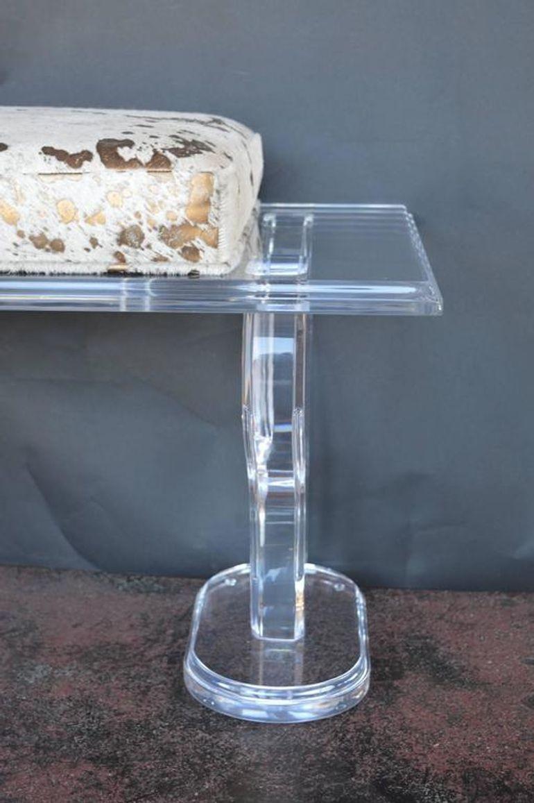 Eine auffällige Lucite-Bank aus den 1980er Jahren, hergestellt in den USA. Mit einem kühnen und luxuriösen Sitz aus gepolstertem Rindsleder mit Goldspritzern. Der transparente Lucite-Rahmen sorgt für einen Hauch von modernem Minimalismus, während