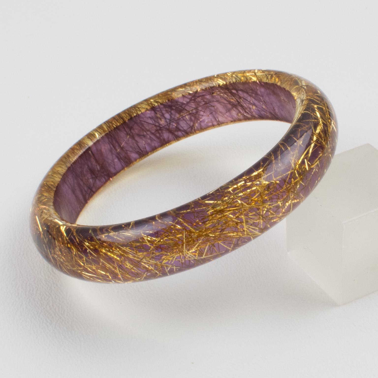 Lovely Lucite bracelet bangle. The bangle has a domed shape and is comprised of clear Lucite which is injected with metallic thread inclusions in gold color with a lavender purple background. The metallic threads sparkle like those of Christmas