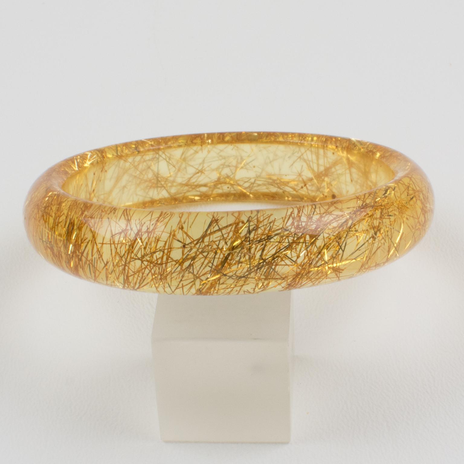 Lovely Lucite bracelet bangle. The bangle has a domed shape and is comprised of transparent yellow Lucite which is injected with metallic thread inclusions in gold color over a frosted background. The metallic threads sparkle as those of Christmas