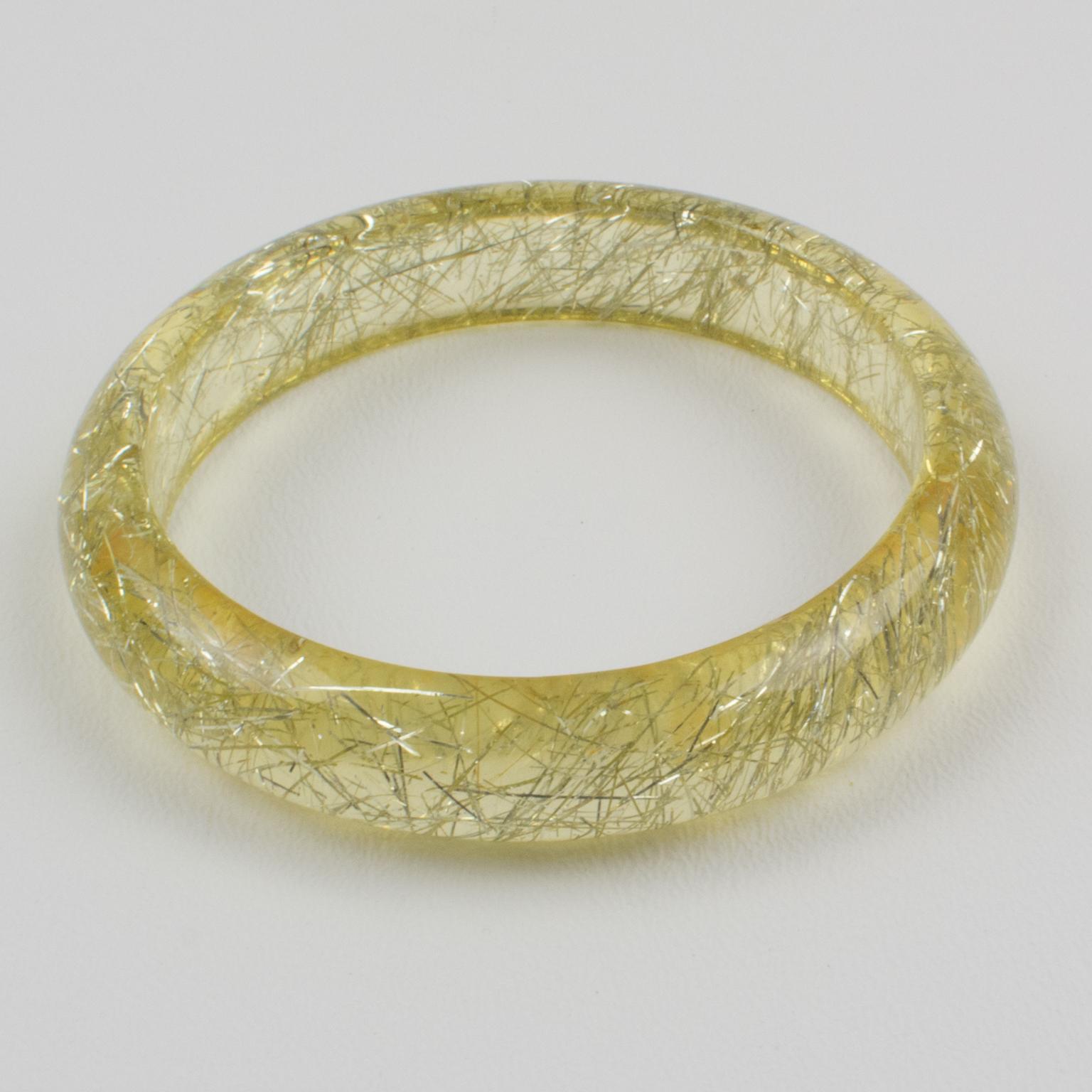 This lovely Lucite bracelet bangle has a domed shape and is comprised of transparent lemon yellow Lucite which is injected with metallic thread inclusions in silver color. The metallic threads sparkle like those of Christmas tinsels. There is no