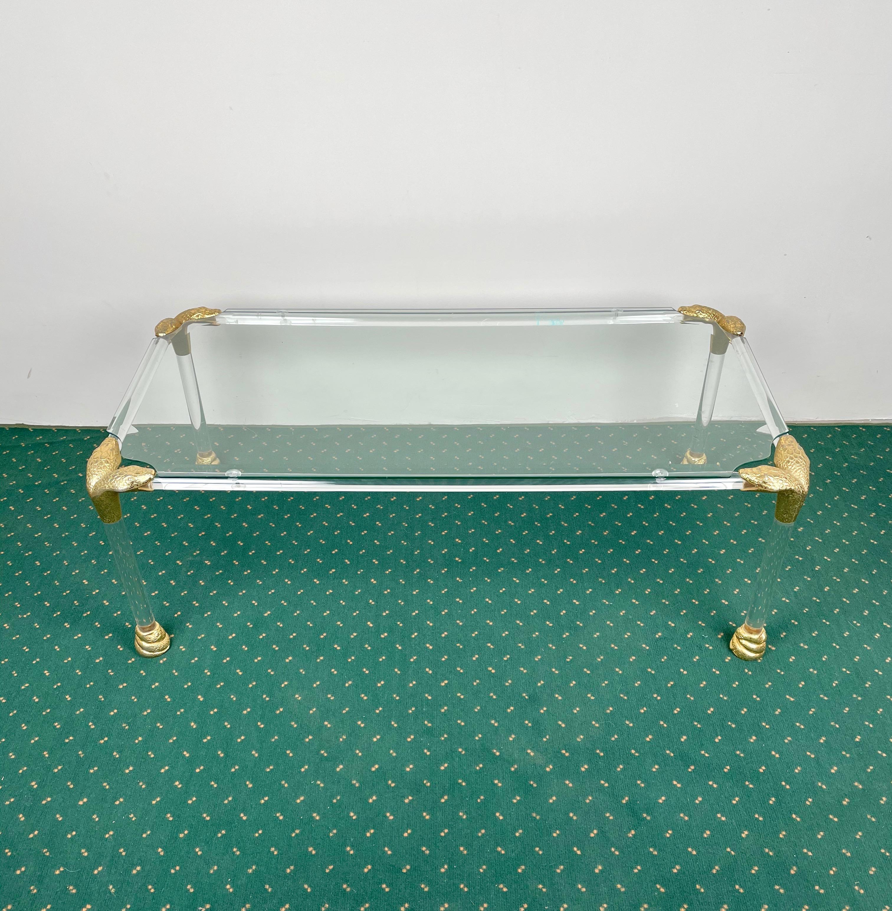 Coffee side table in Lucite with snakehead-shaped brass corners. Made in Italy in the 1970s.
Overall conditions are very good, there are just some tiny scratches on the glass due to the age of the table.

  