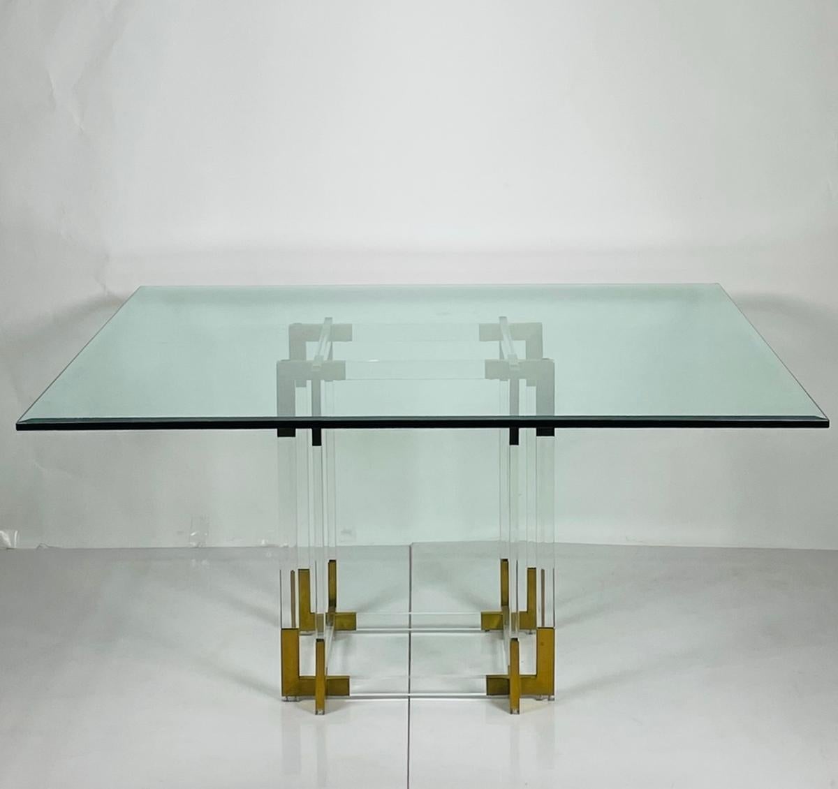 Voici l'étonnante table de salle à manger en lucite et laiton de Charles Hollis Jones, un véritable chef-d'œuvre du design moderne du milieu du siècle dernier. Fabriquée aux États-Unis dans les années 1960, cette table de salle à manger exquise