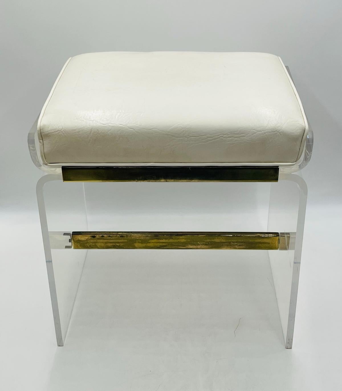 Introducing the Lucite & Brass Vanity Bench by Charles Hollis Jones, a stunning piece of furniture that exudes elegance and sophistication. This vintage bench from the 1960s features a sleek design, hand crafted in Los Angeles, California.
The