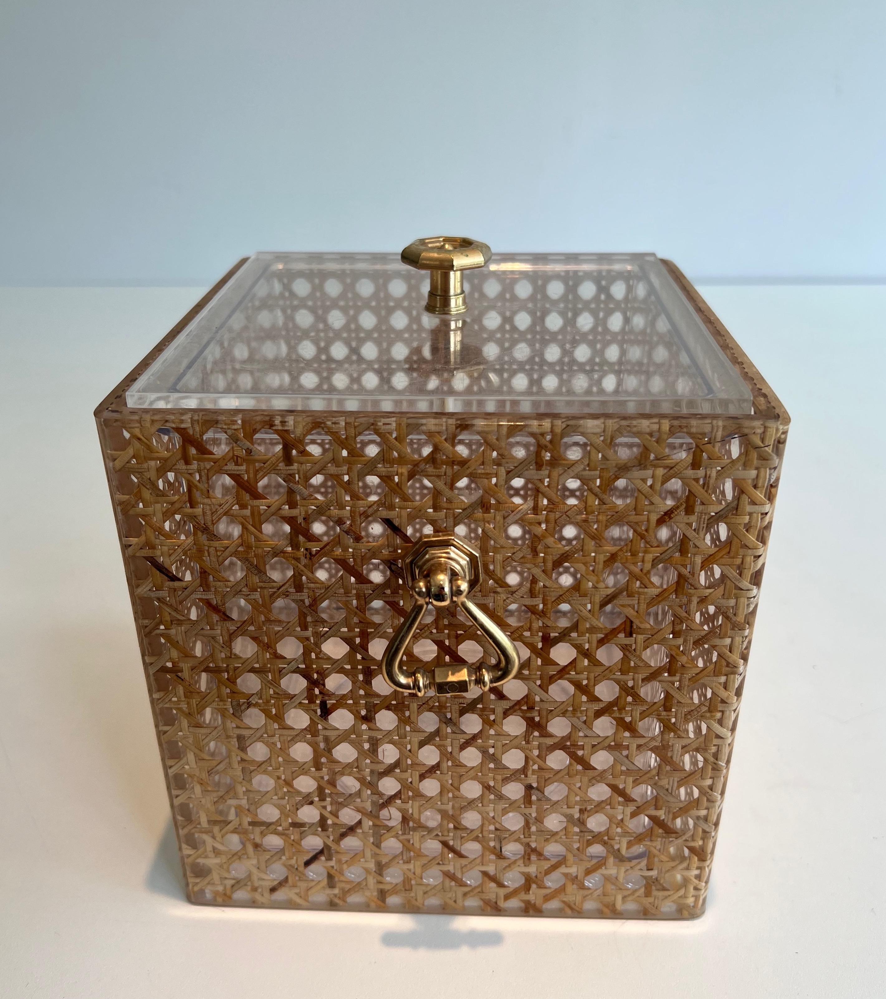 This very nice and elegant ice bucket is made of lucite with cane incrusted in lucite and brass. This is an Italian work in the style of Christian Dior. Circa 1970