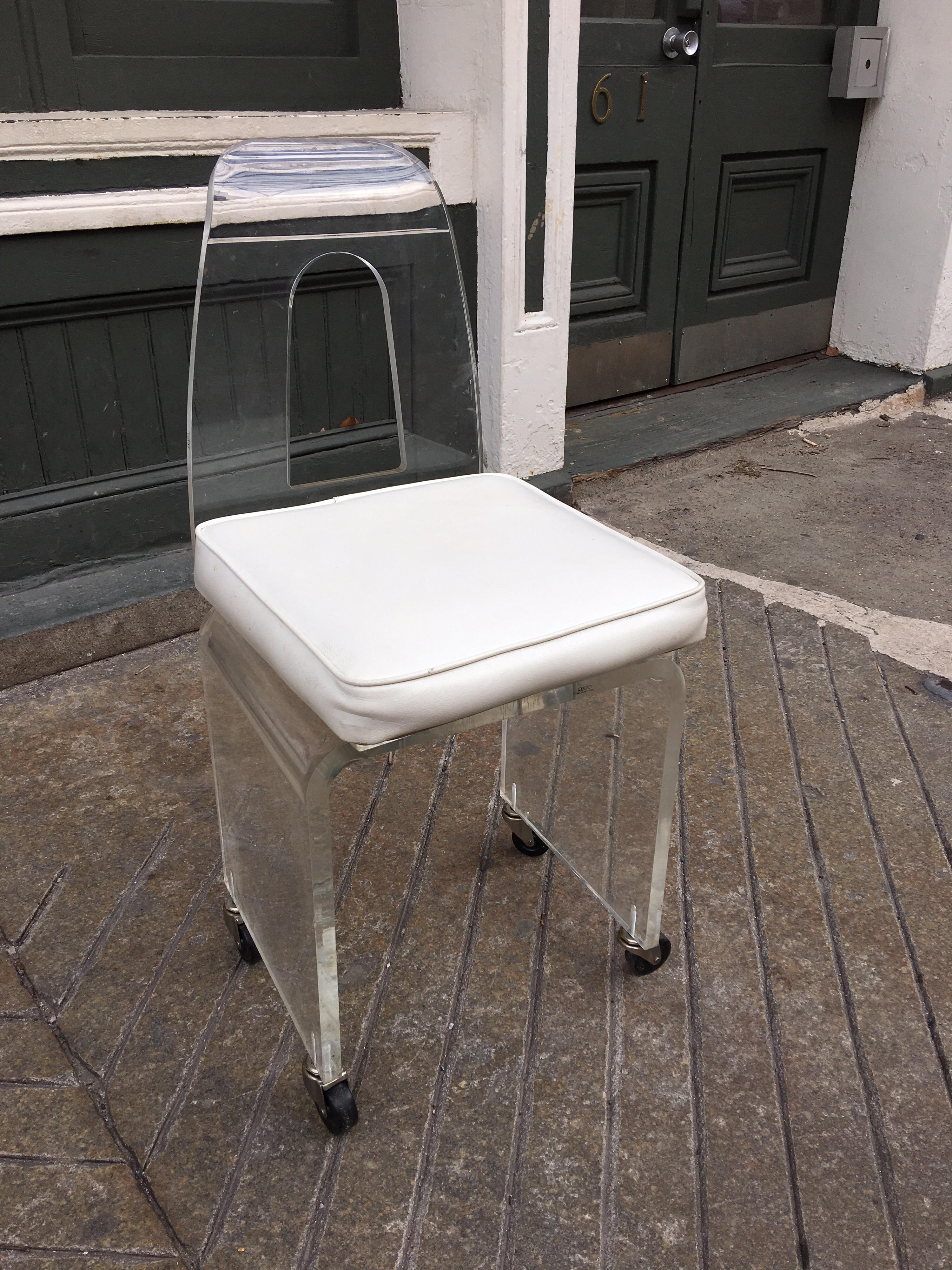 Lucite chair on wheels with upholstered swiveling seat. Cut-out Lucite back!