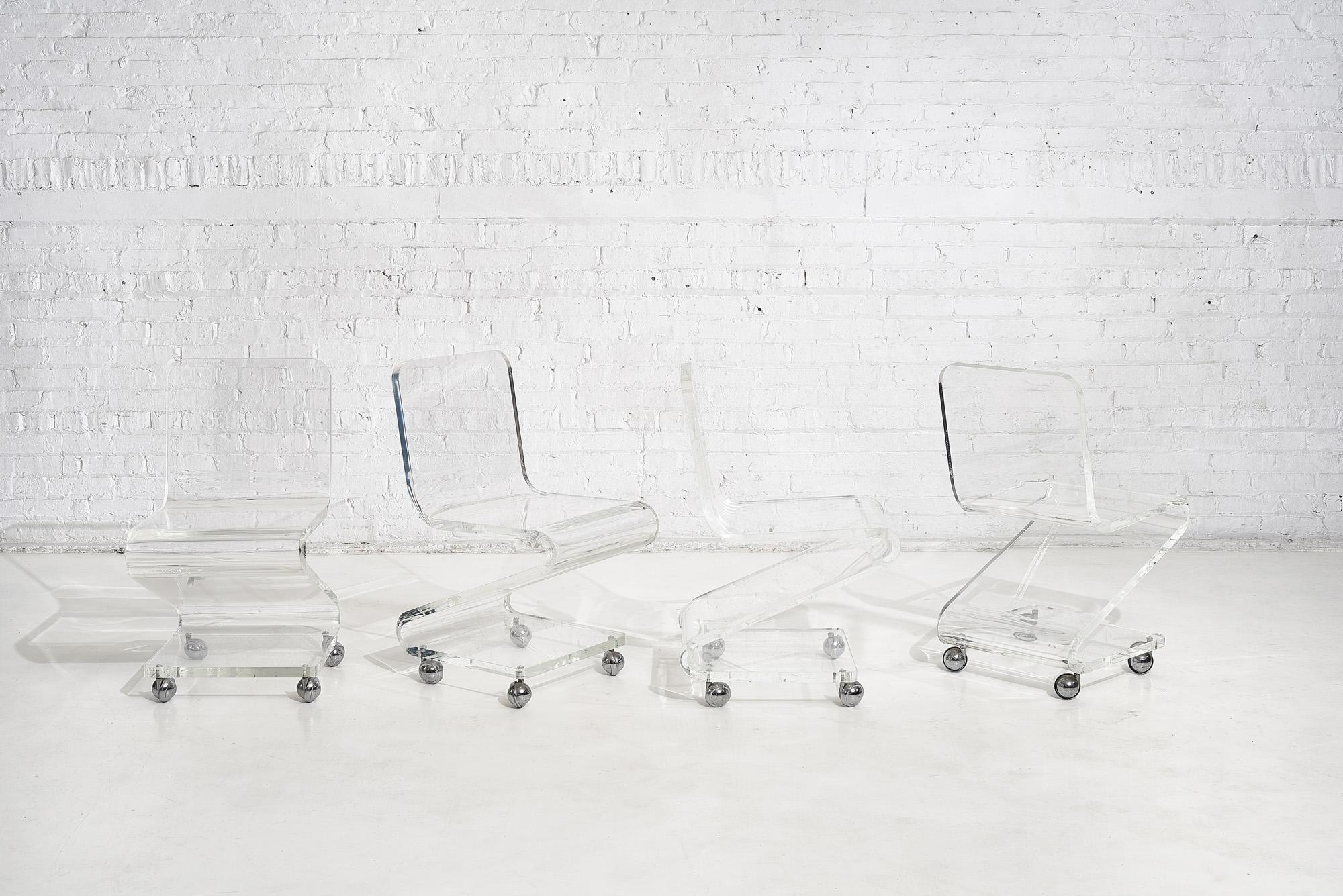 Les Prismatiques Lucite chairs on casters, circa 1970s. Set of 4 heavy Lucite.