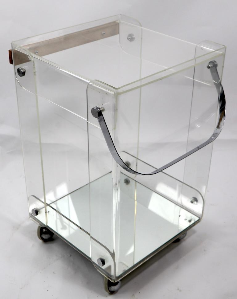 Chic serving cart in Lucite with chrome handle, mirrored bottom shelf, and wood butcher block top. This service trolley is mounted on original ball coaster feet, the butcher block top is removable should you want to use it as a serving rather than a