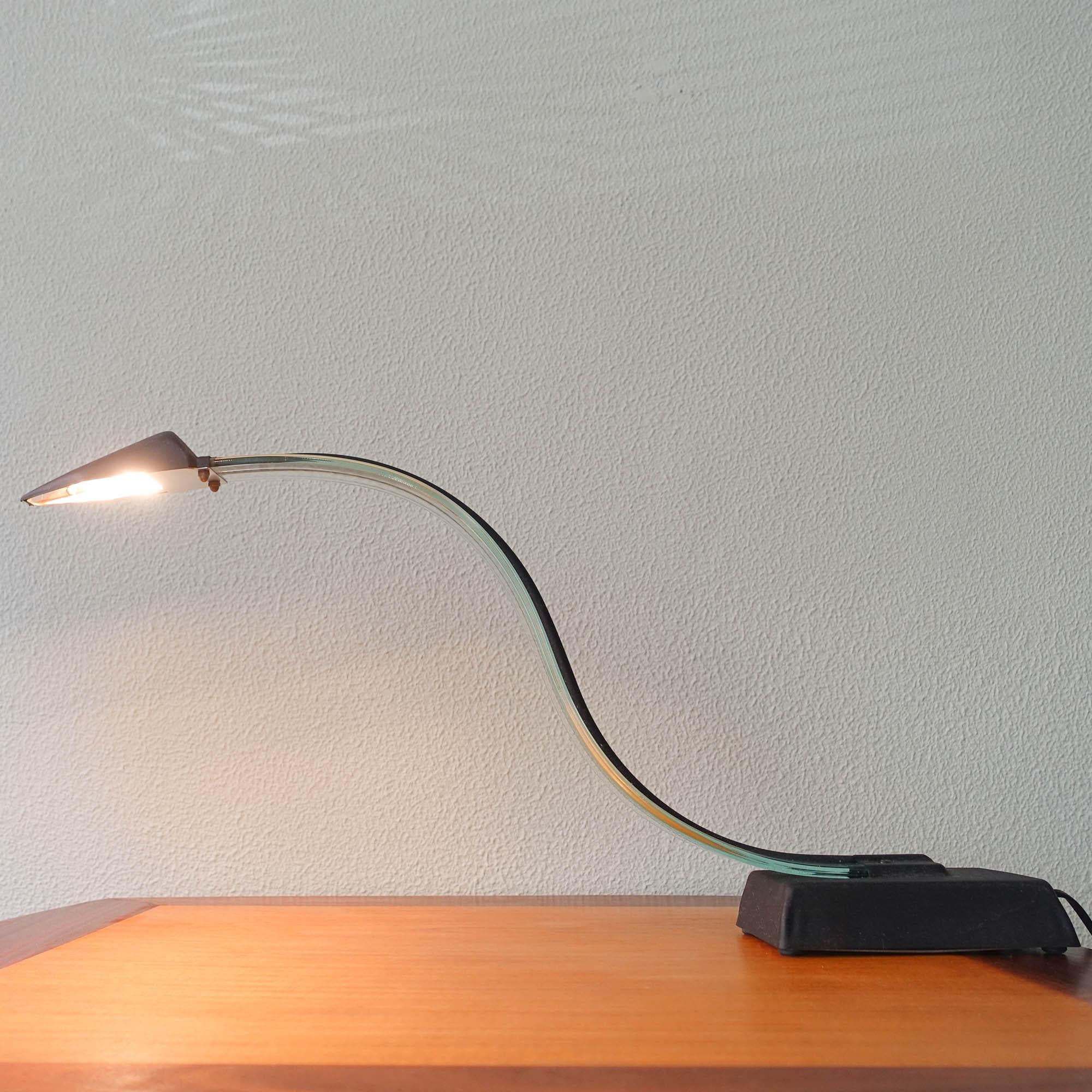 Cette lampe de table a été conçue et fabriquée en Italie dans les années 1980. Il présente un bras incurvé en Lucite et un abat-jour et une base en métal noir.
En outre, la lampe de bureau est dotée d'un interrupteur à deux positions et d'une