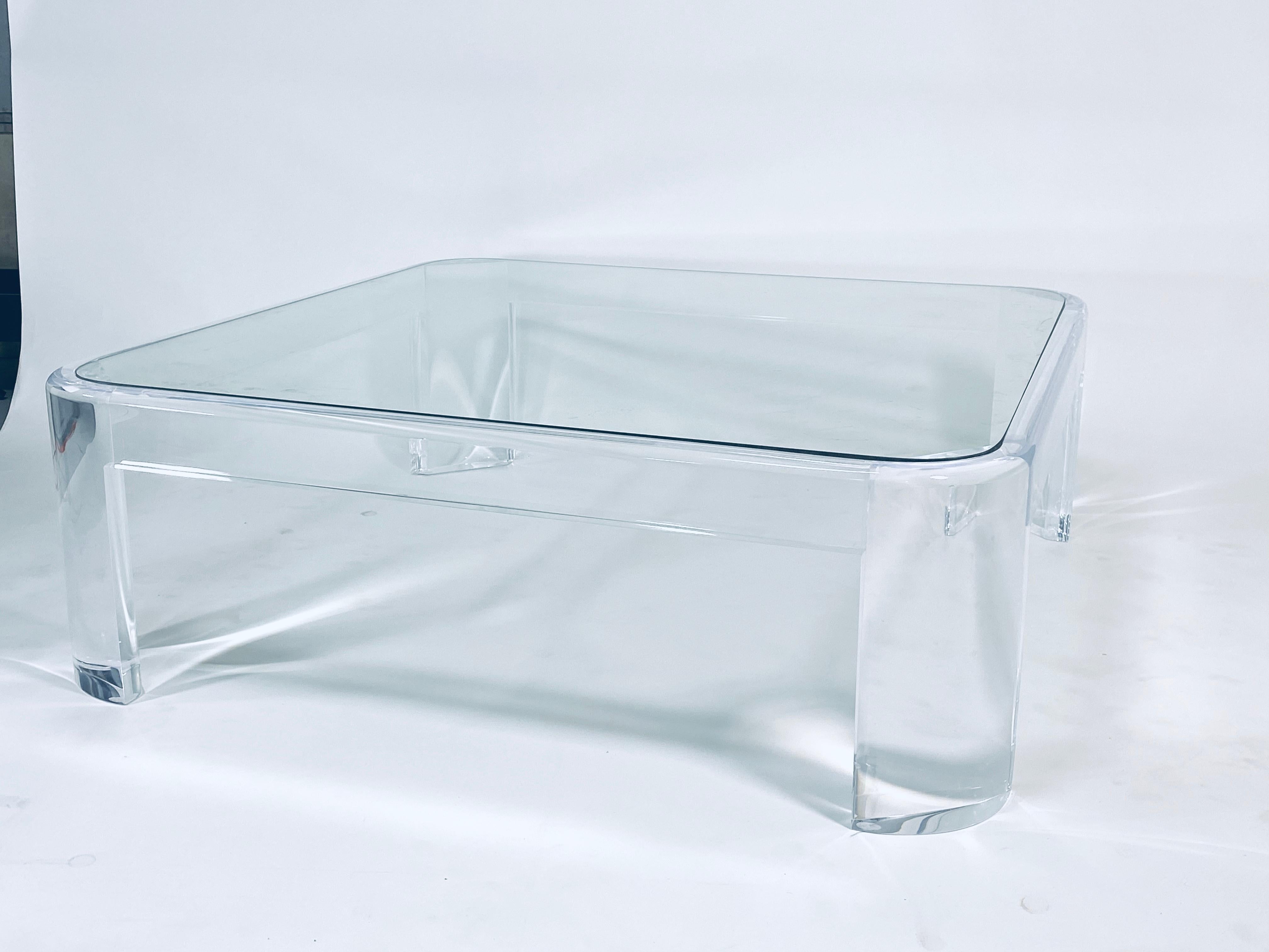 Thick lucite coffee table with rounded radius corners and flush mounted glass top by Les Prismatiques, circa 1970s.