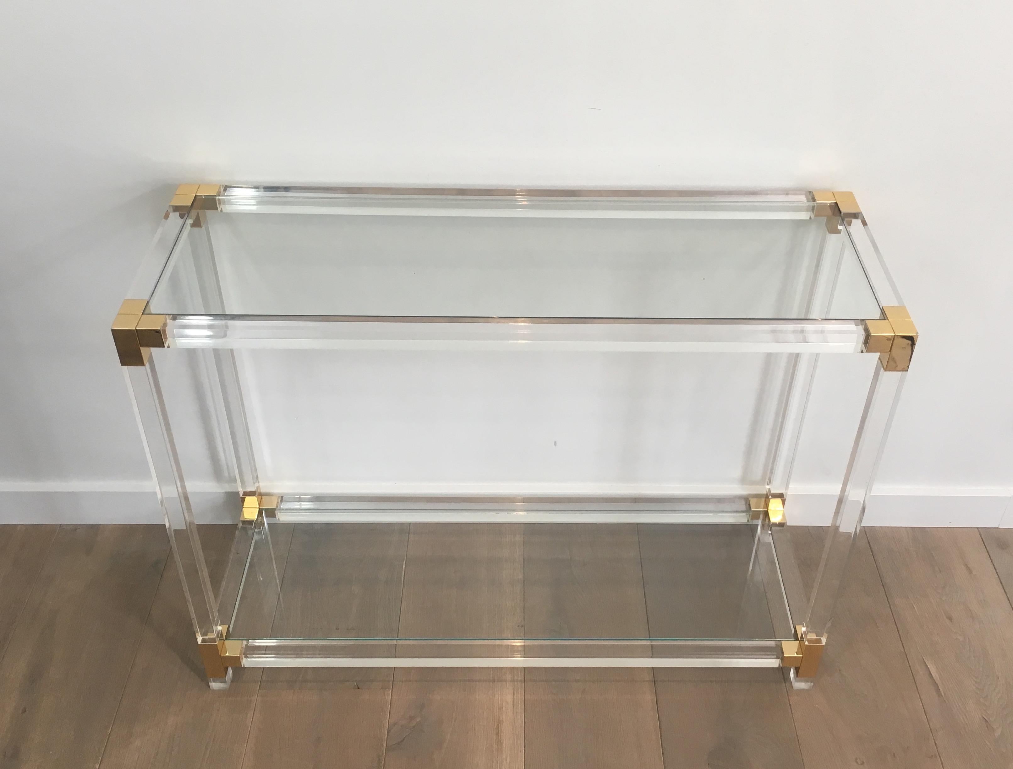 This console table is made of a Lucite base with gold gilt pieces on corners. This is a French design in the style of Maison Jansen, circa 1970.