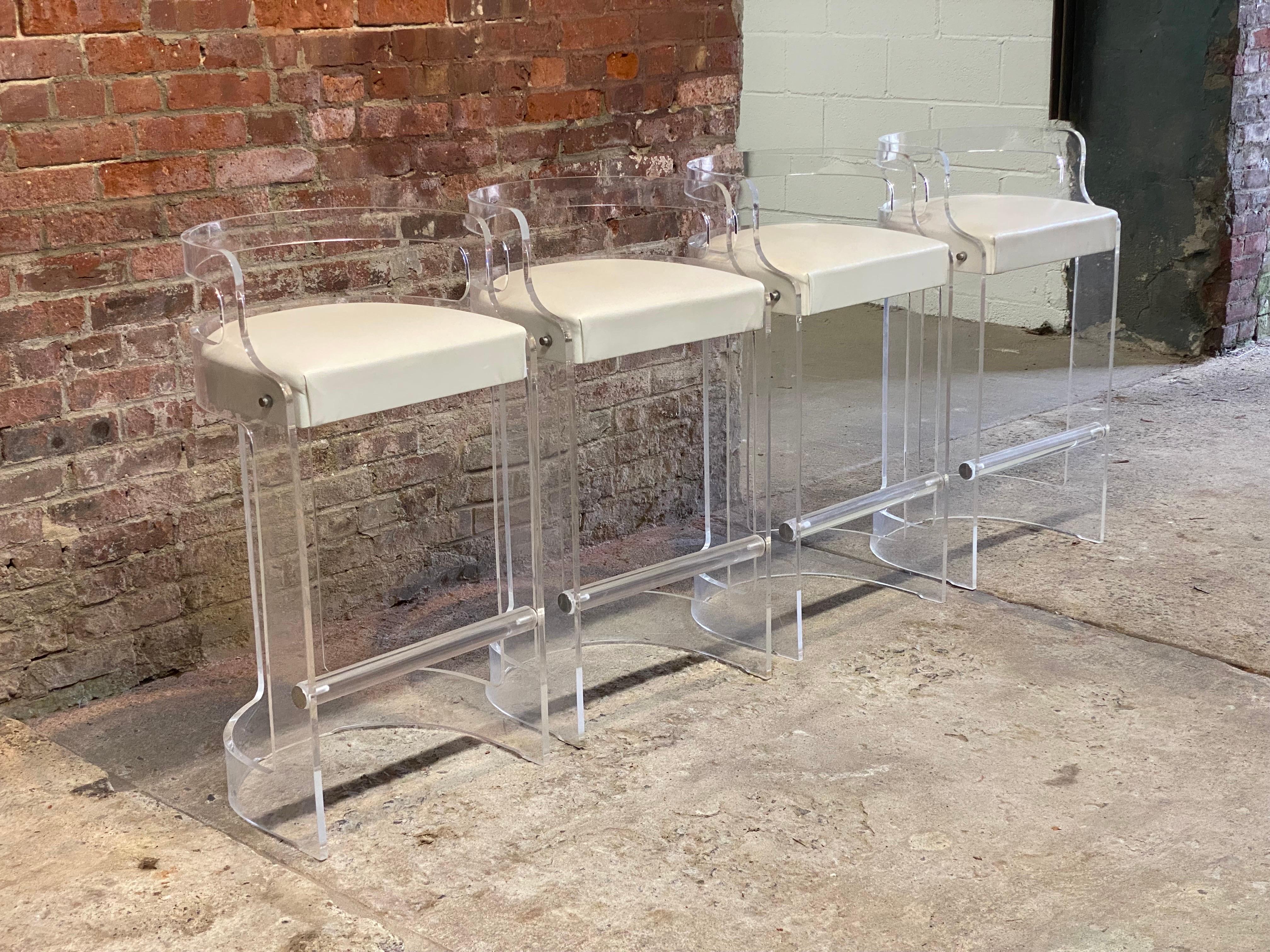 Set of four clear acrylic (Lucite) bar or counter stools produced by Hill Manufacturing Company, Newburgh , New York. Circa 1990-2000. One example is signed with its original label. Crystal clear lucite barrel back stools with foot rest and each is